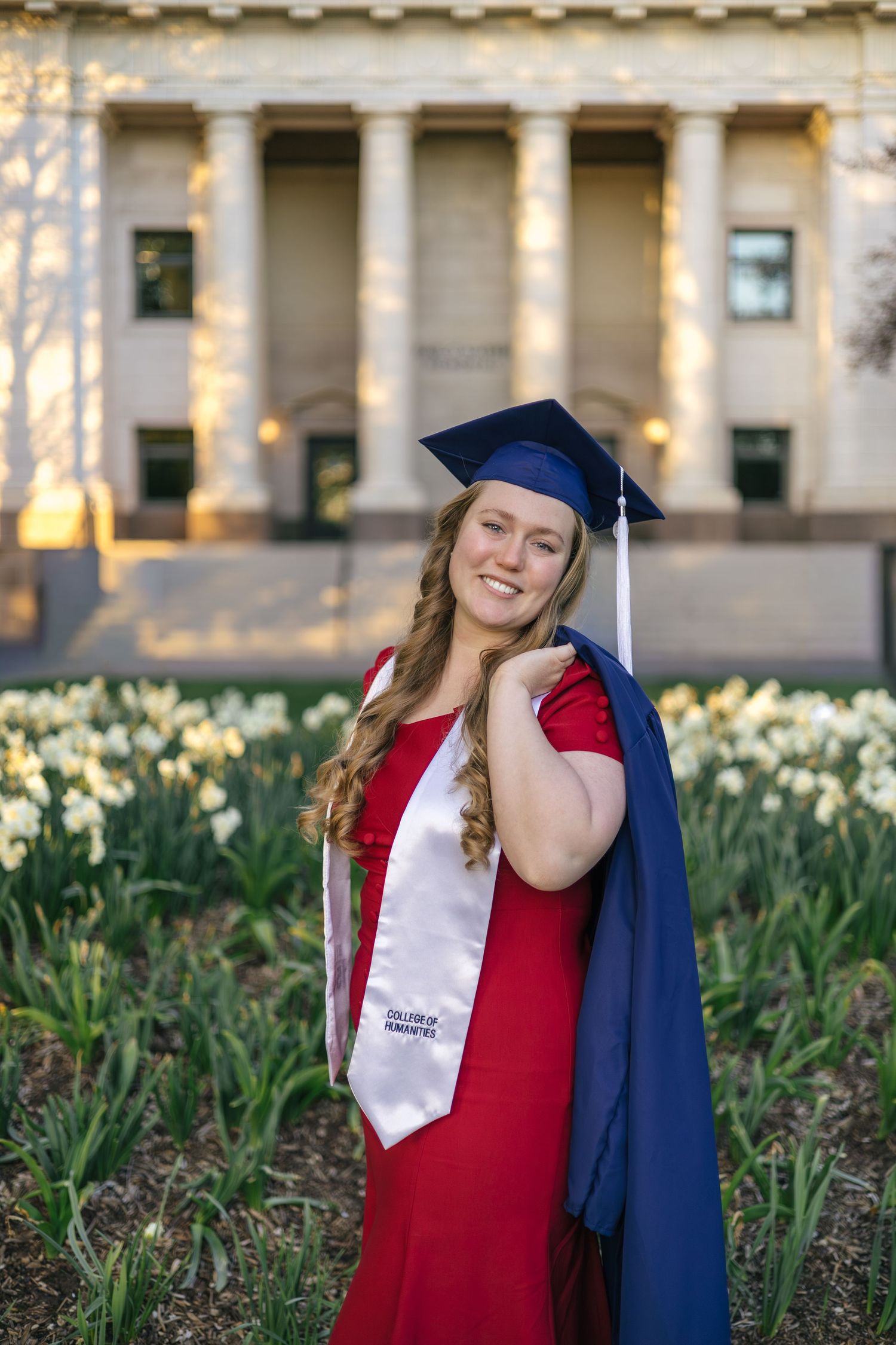 byu graduate holding graduation gown over her shoulder