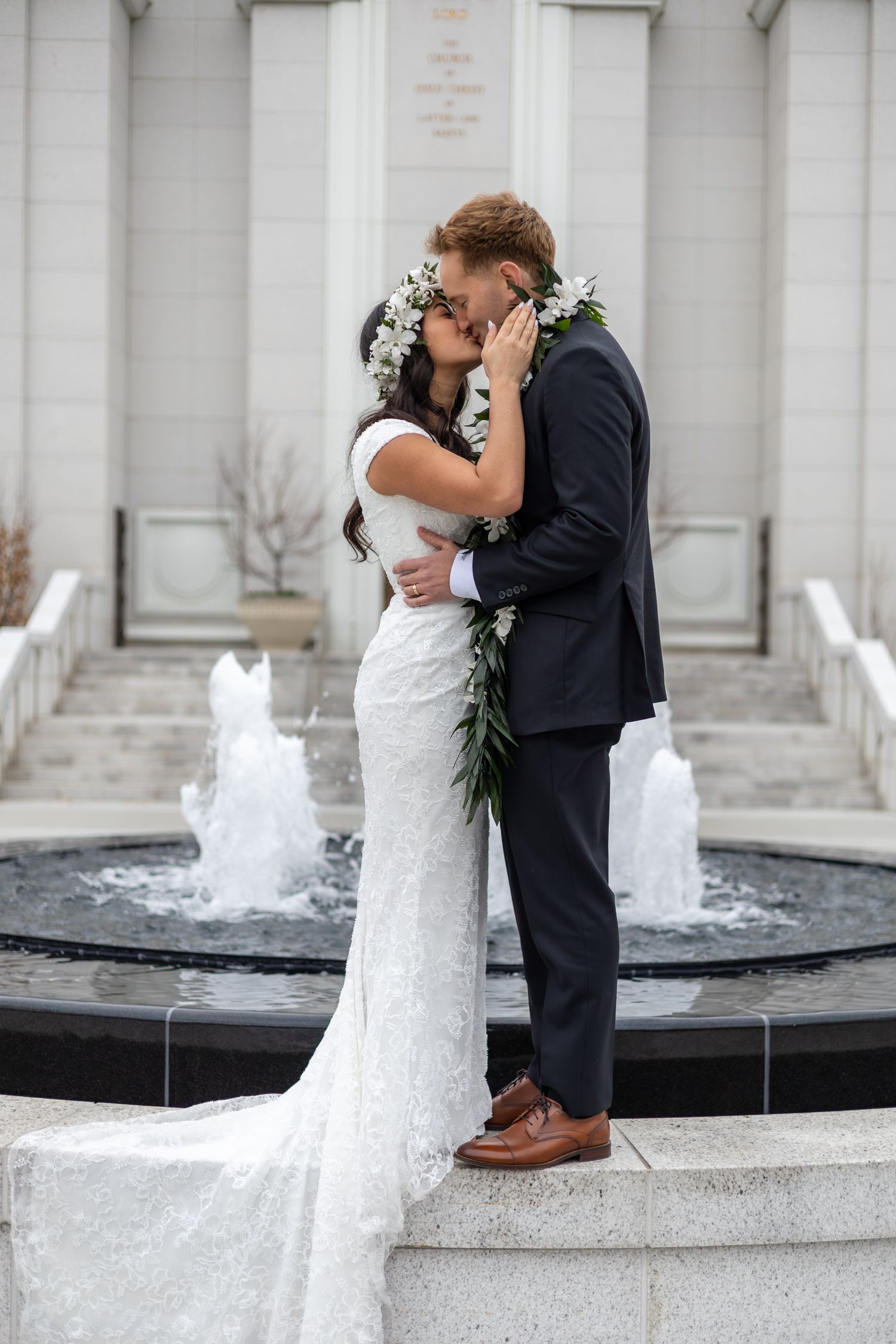 couple kissing outside an LDS temple after wedding ceremony in utah