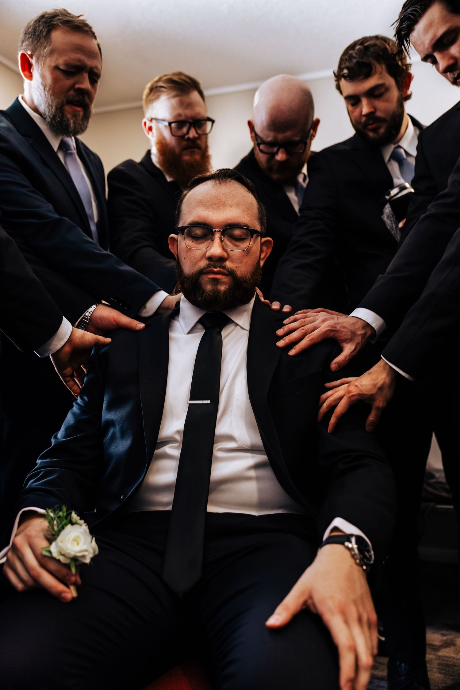 groom praying with wedding party before ceremony