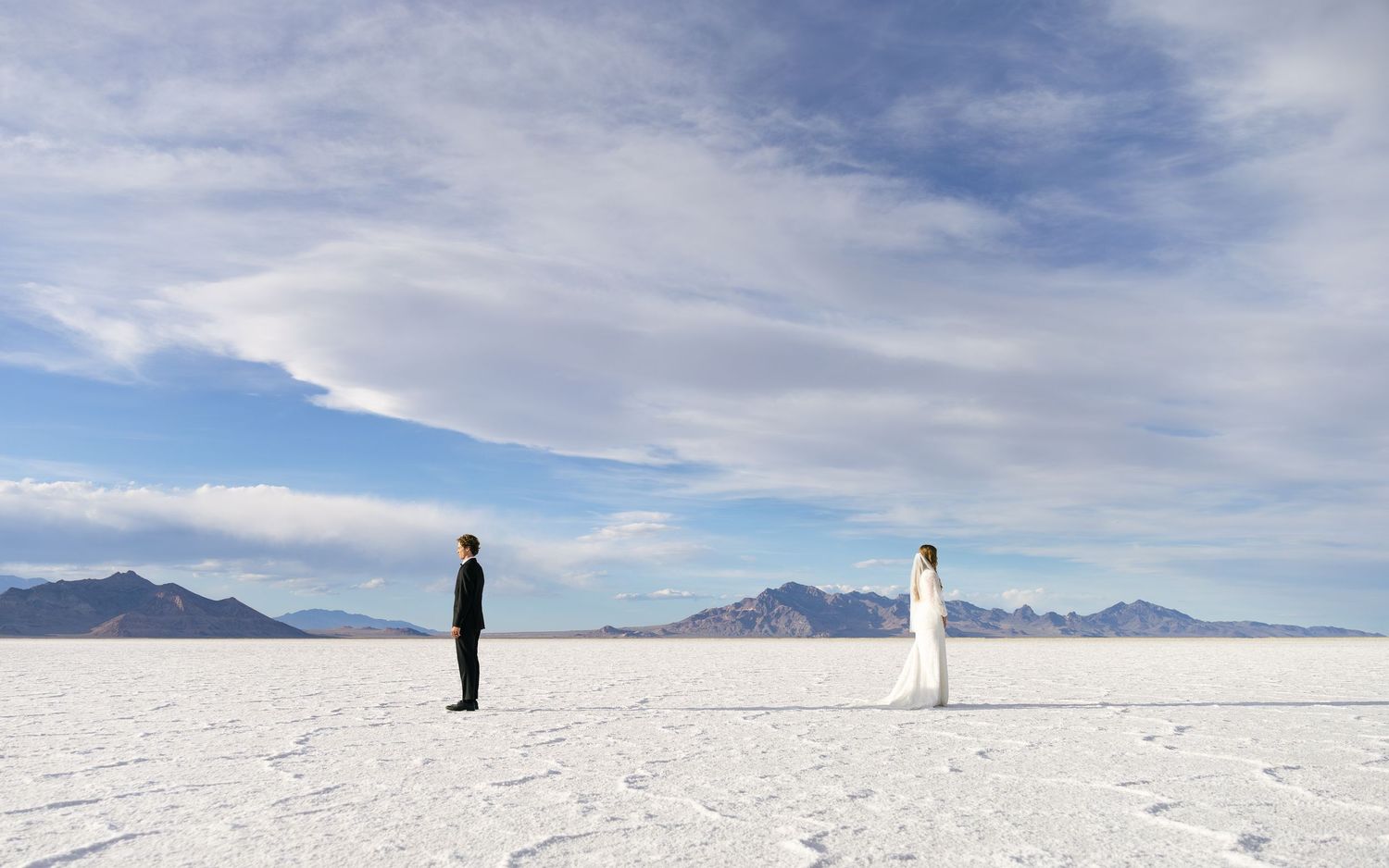 couple facing away from each other, about to have their first look on the Utah salt flats
