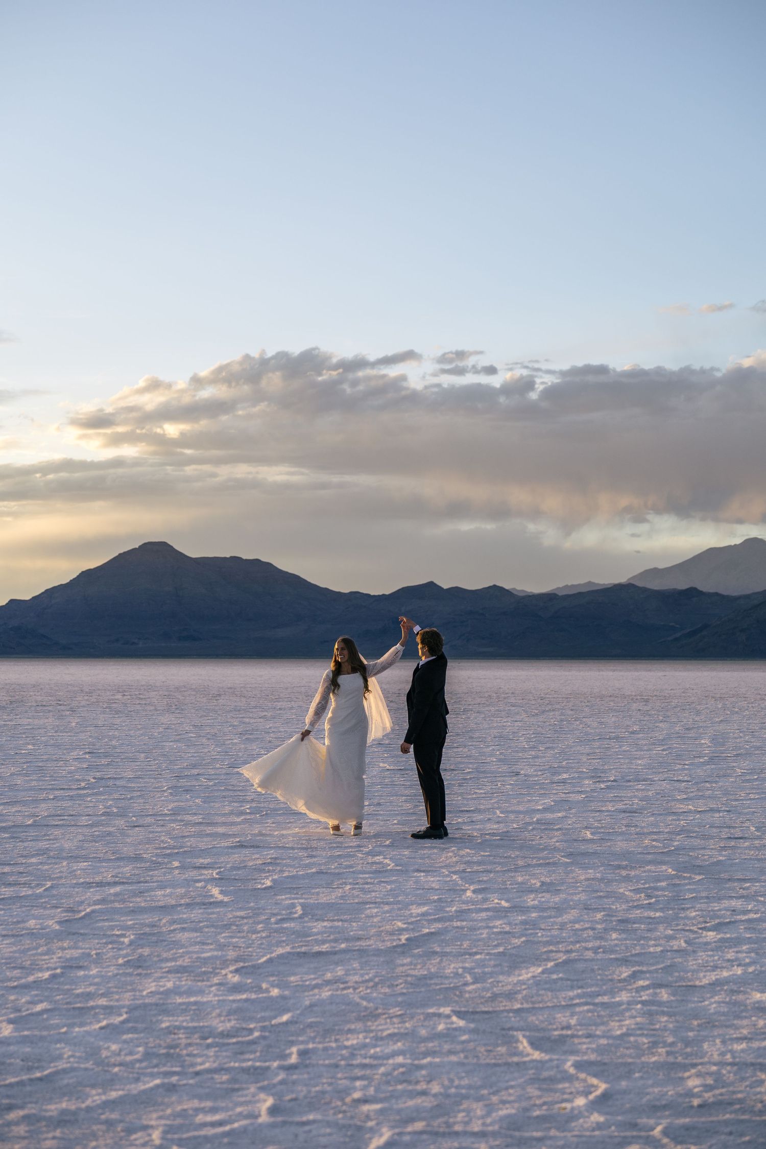 couple twirling on the Utah salt flats at sunset