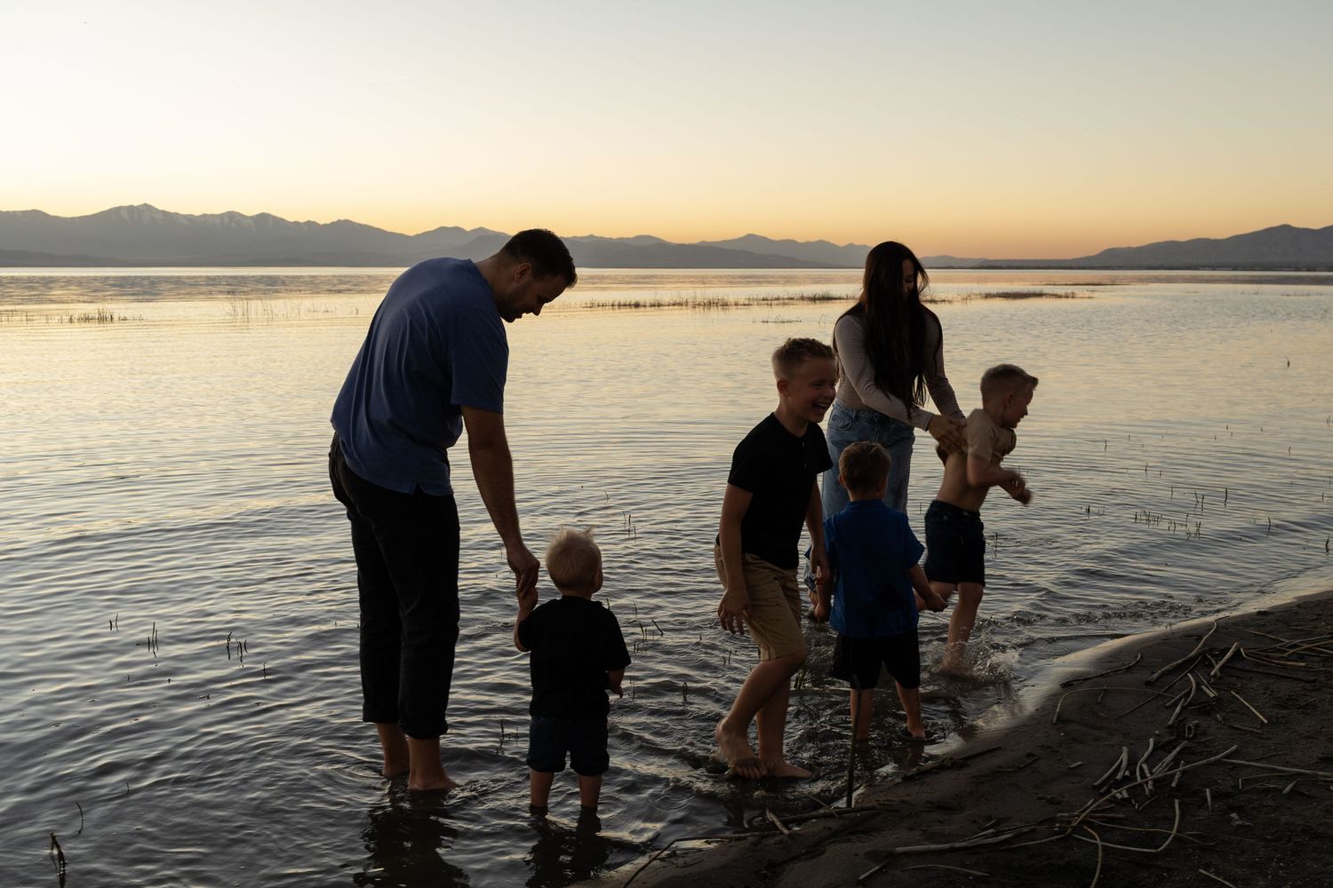 family photos at utah lake at sunset, playing in the water