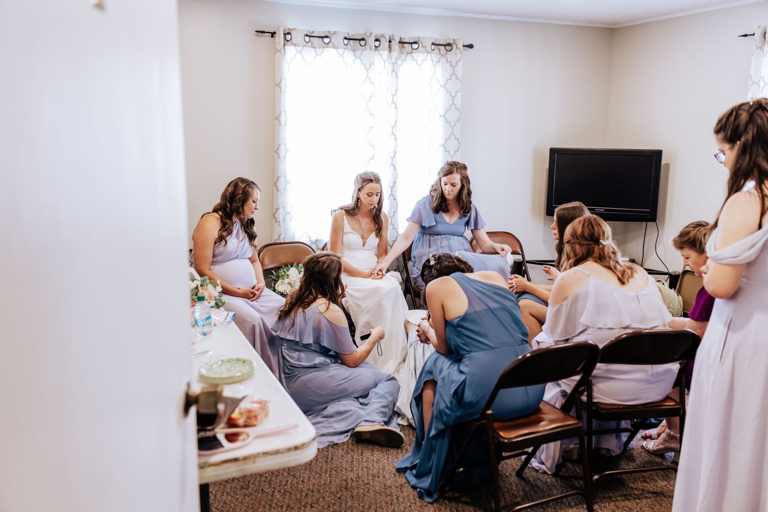 bride praying with wedding party before the ceremony