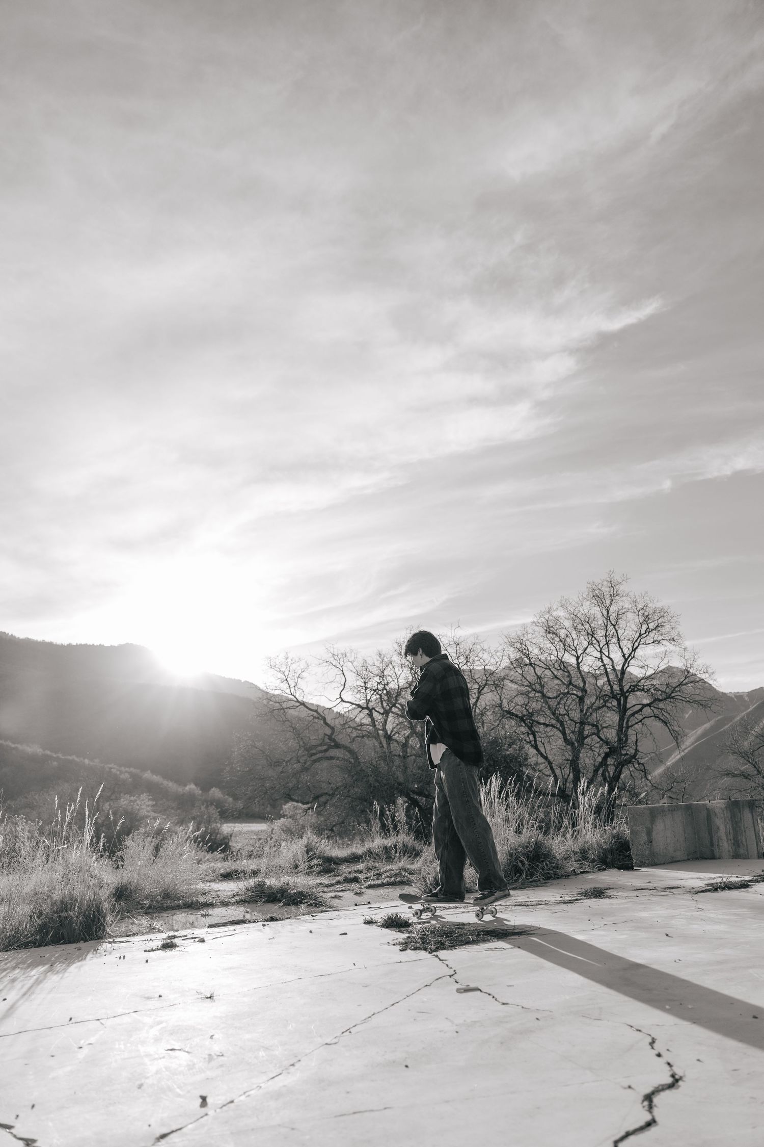 senior boy skateboarding at sunset