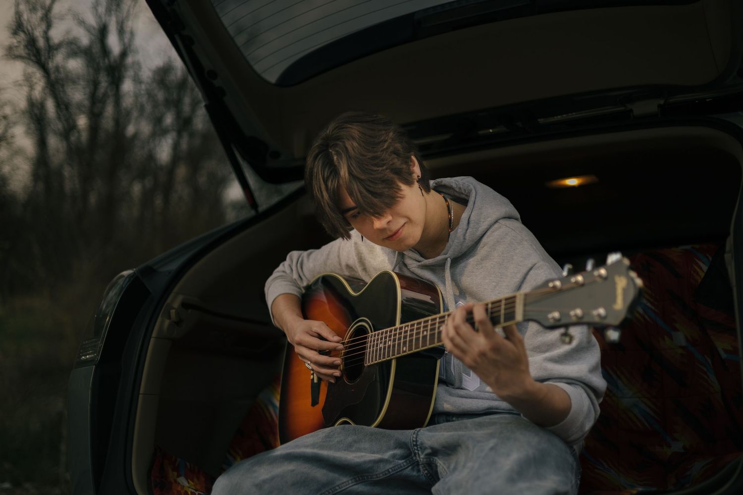 senior boy playing his guitar for a senior picture session