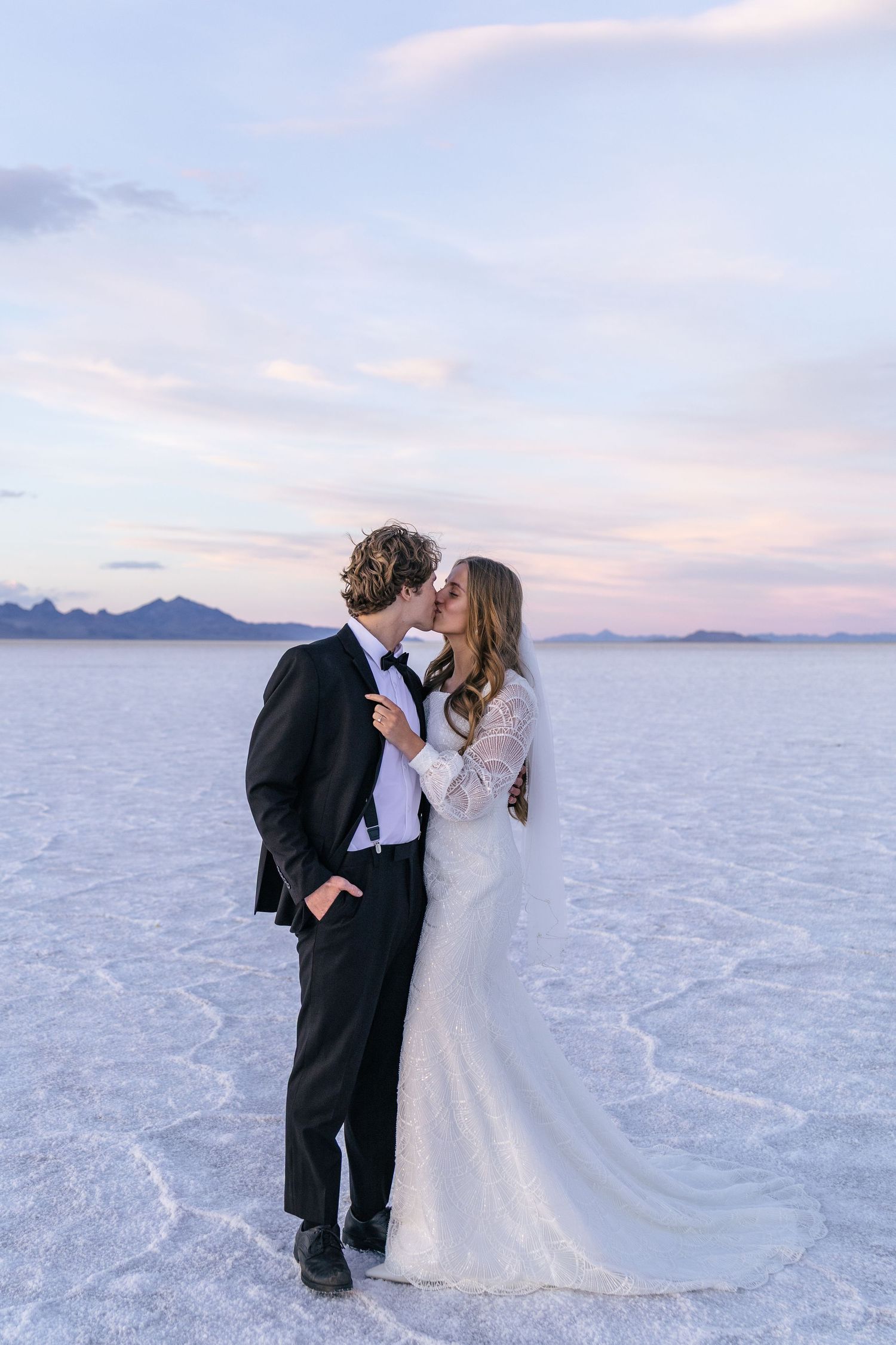 couple in wedding clothes kissing on the Utah salt flats at sunset