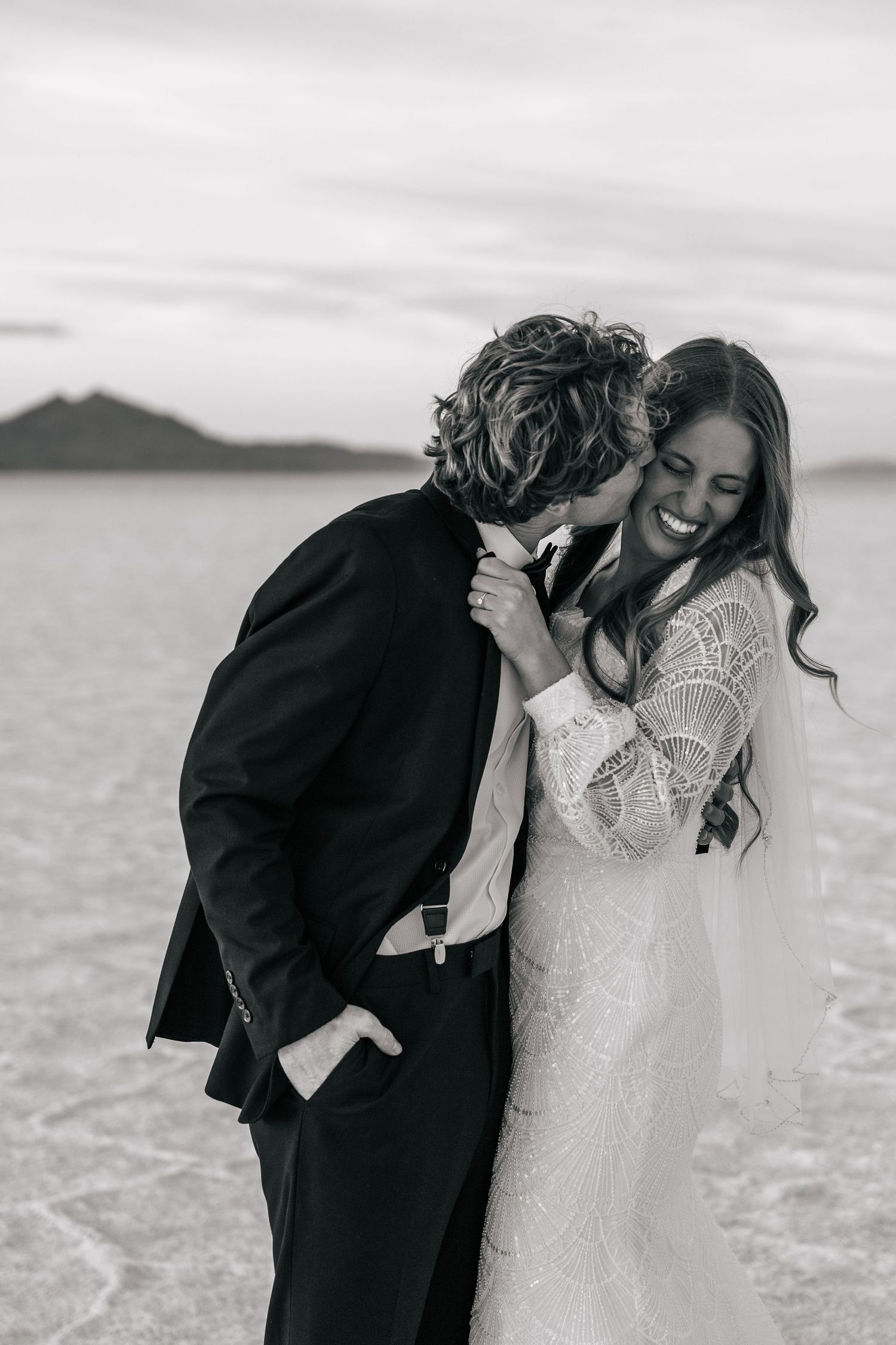 couple laughing on the Utah salt flats at sunset