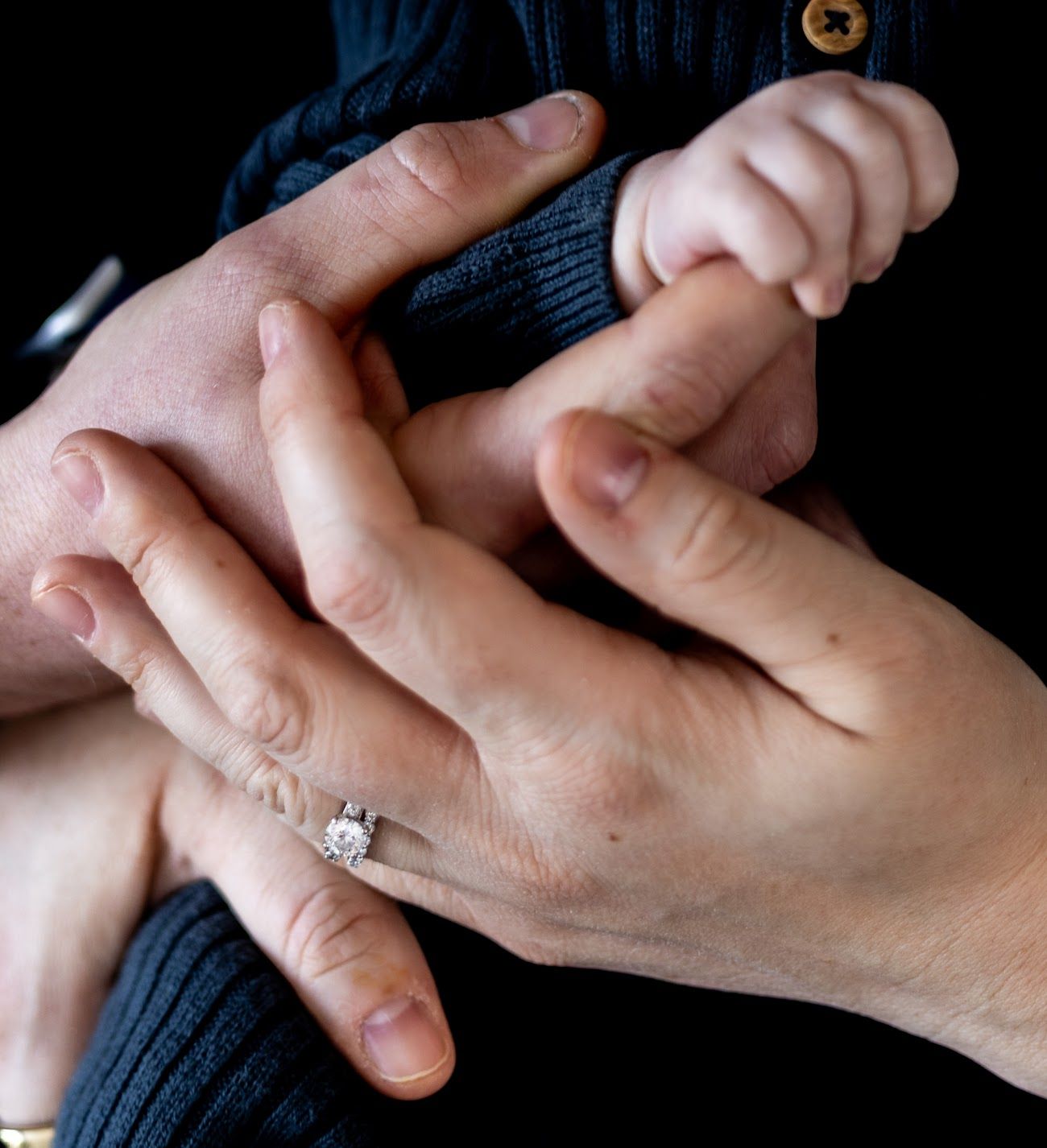 Close-up photo series showing someone placing an engagement ring on another person's hand.