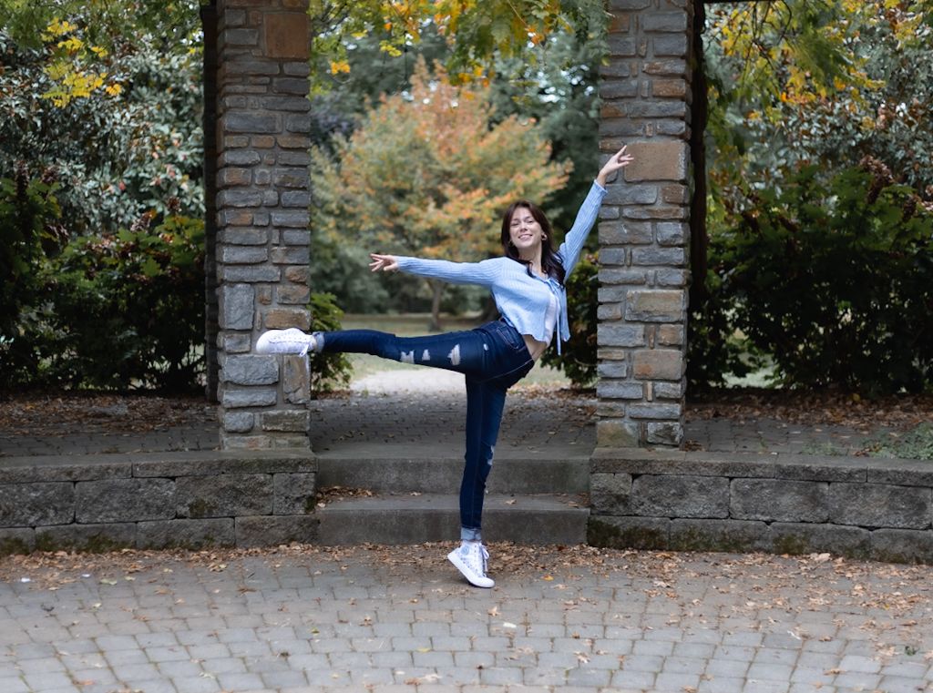 Dancer performs a graceful sequence of high kicks against a stone wall backdrop in autumn. Cincinnati/ northern Kentucky