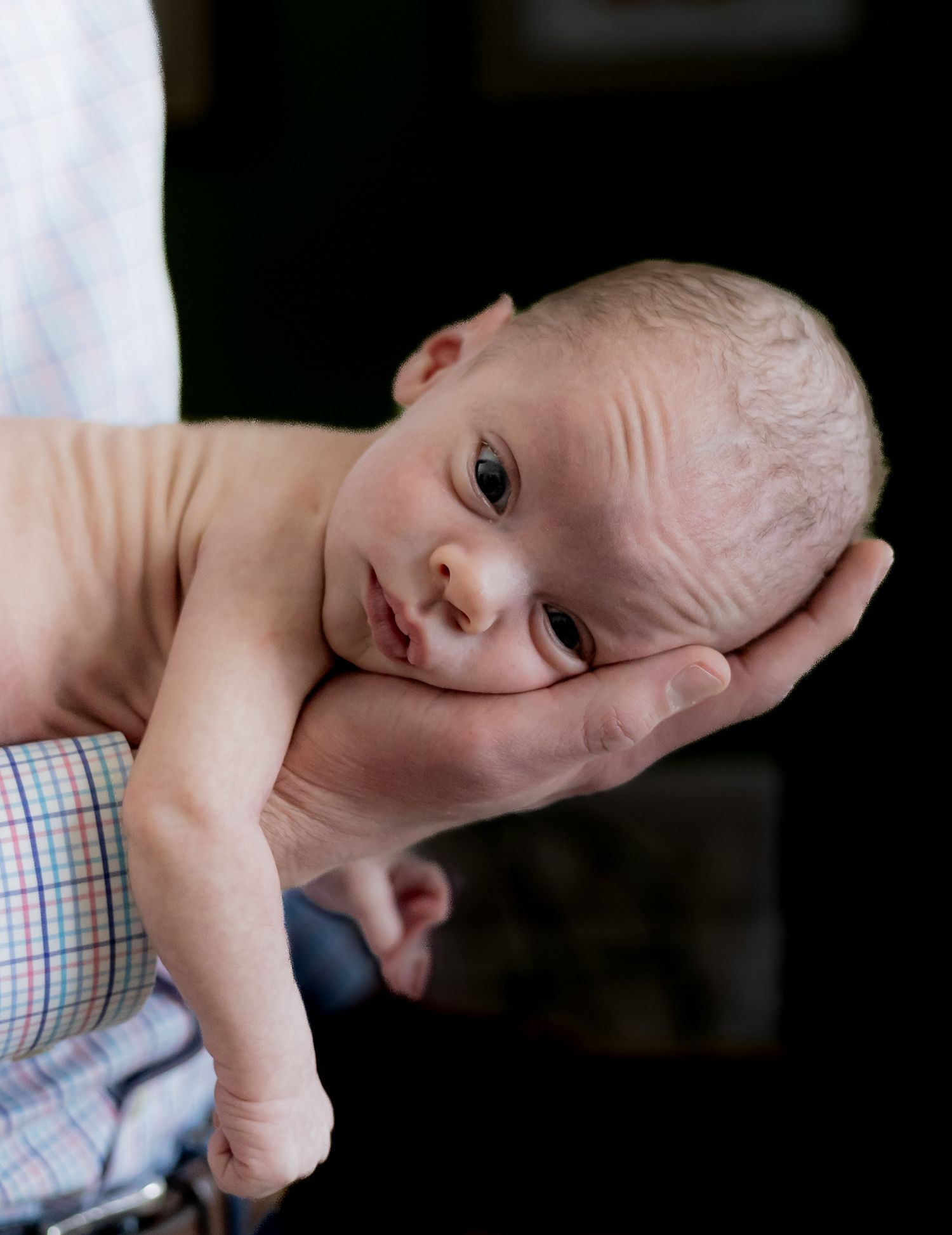 A newborn baby lies in his father's hand- black and white photographs showing different angles. Cincinnati/ Northern Kentucky