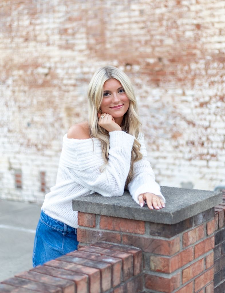 Casual portrait series against a rustic brick wall featuring white top and denim in various relaxed poses.