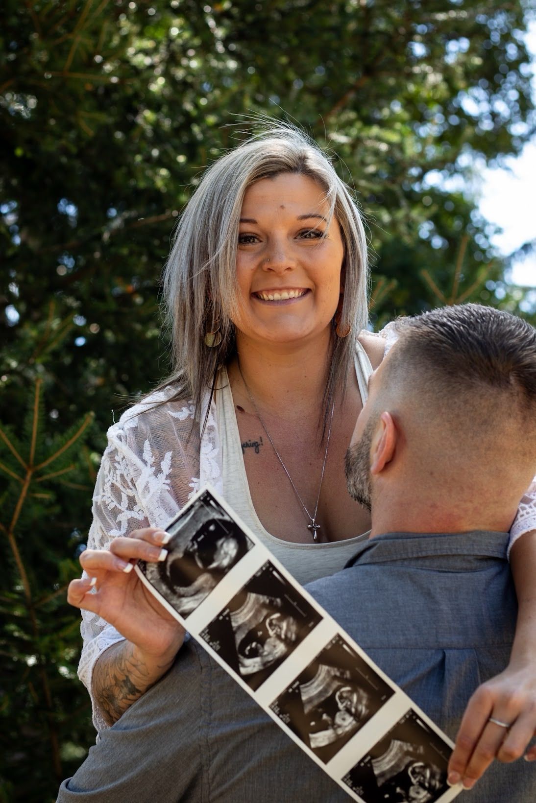 A series of photos showing someone in a gray shirt holding up an ultrasound image in an outdoor setting.