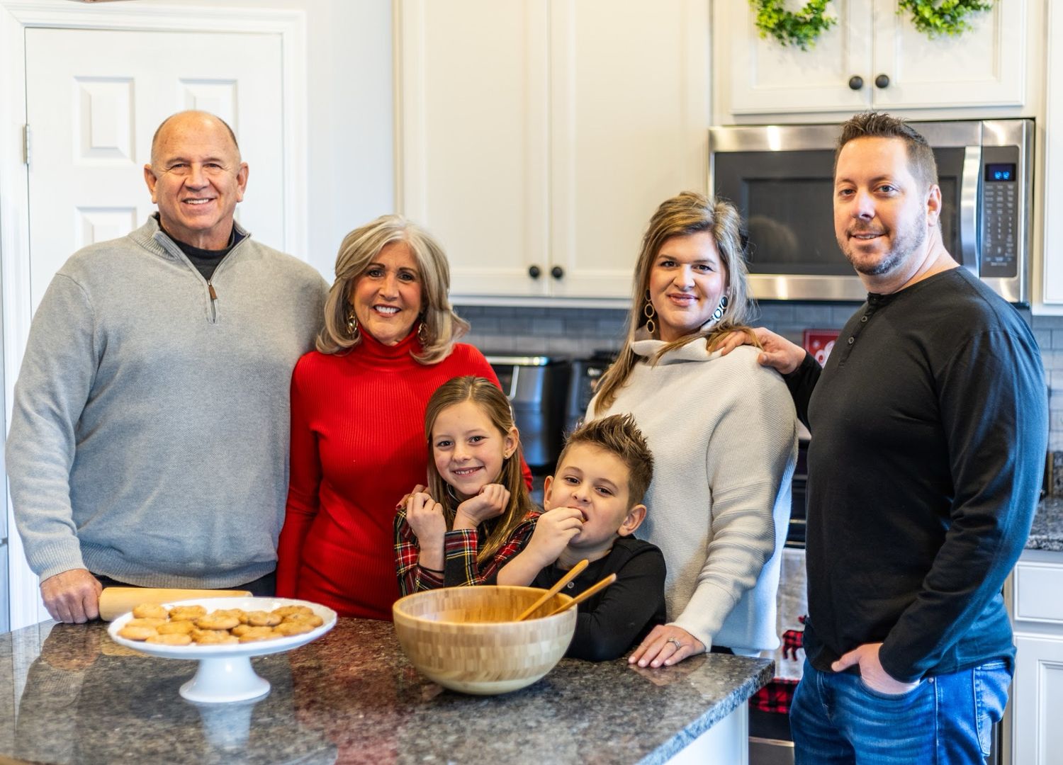 A family photo showing people gathered in a kitchen area baking cookies during a holiday celebration.