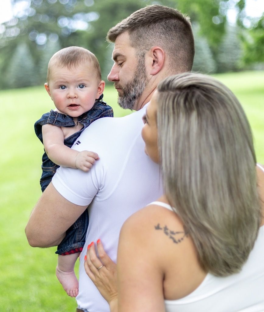 A couple shares tender moments with their baby outdoors in a series of candid family photos. Cincinnati/ Northern Kentucky