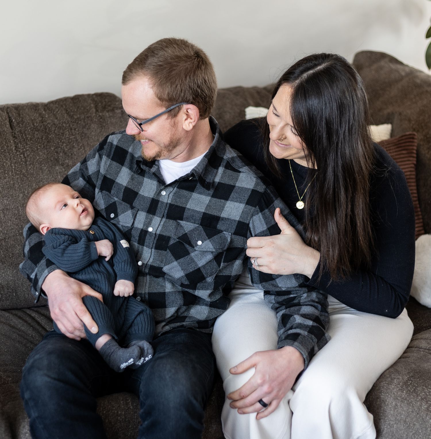 Family snuggling together on a gray couch in a series of tender moments. Cincinnati/ Northern Kentucky
