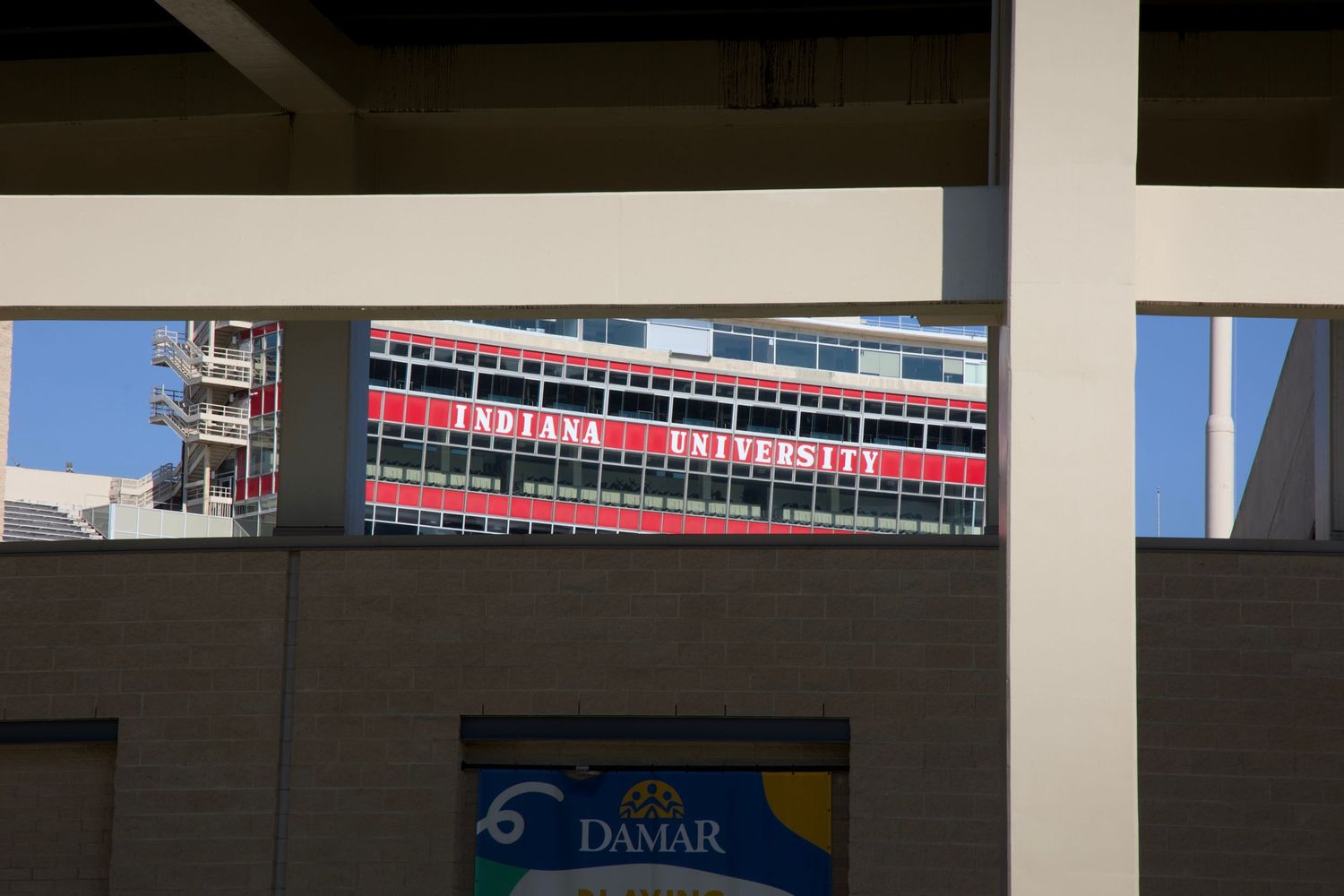 A peep between the foundation of Indiana University Bloomington's Memorial Stadium, showcasing the lettering on the press box.