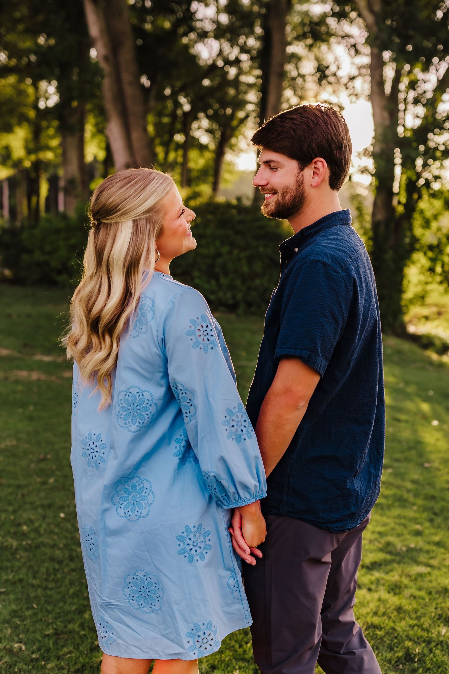 A couple sharing an intimate moment in a sunlit garden setting.