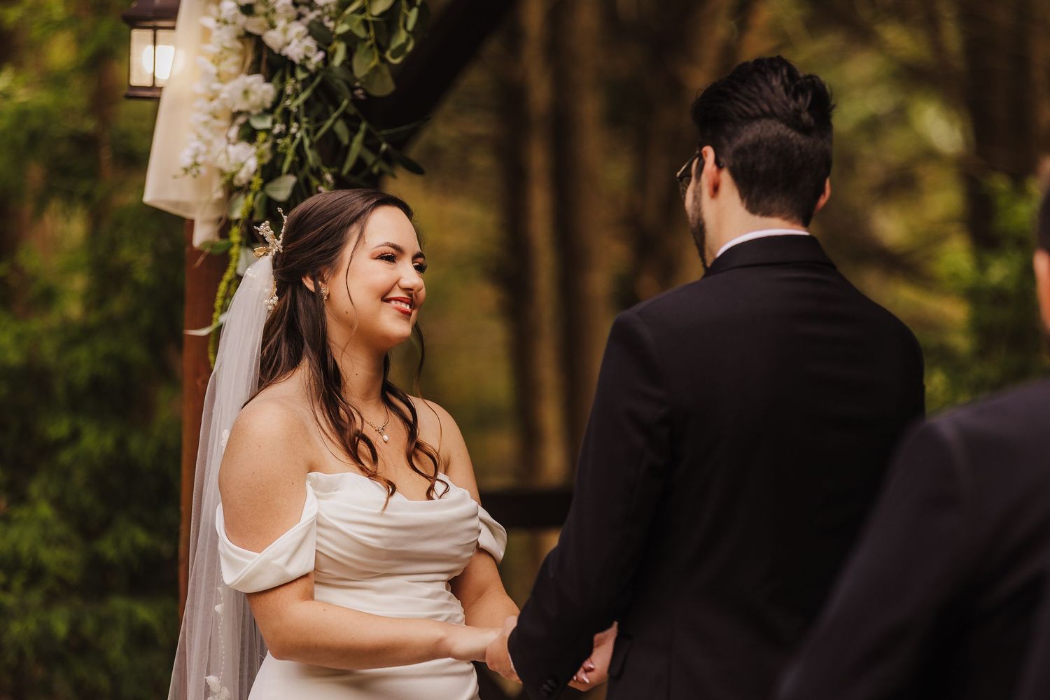 A bride and groom share intimate moments during their outdoor forest wedding photoshoot.