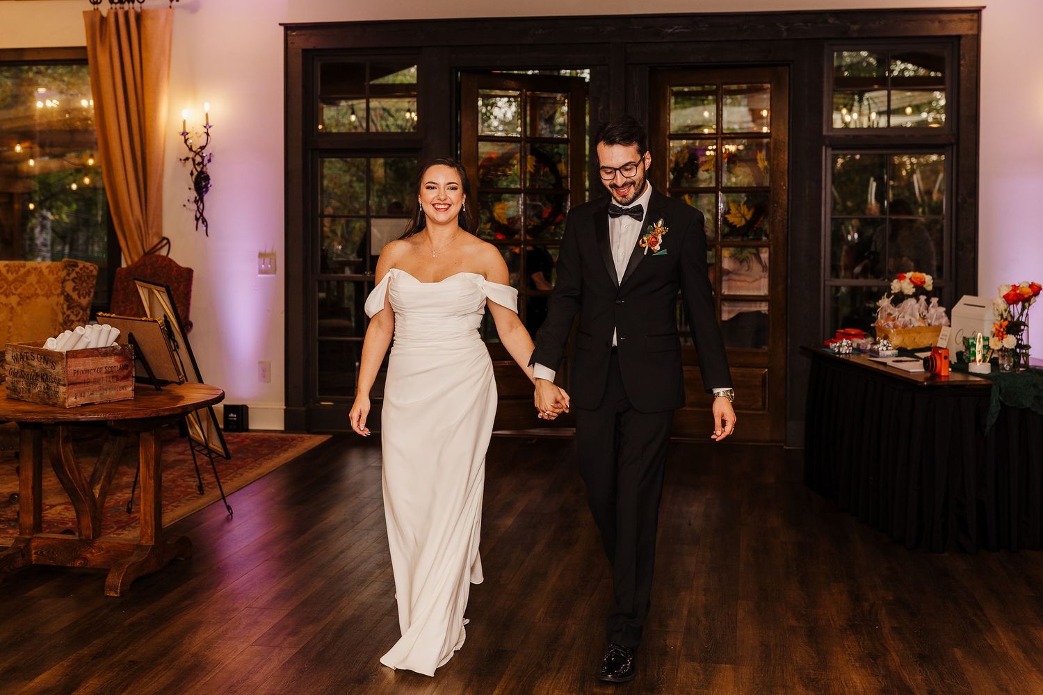 Elegant wedding reception venue with wooden floors and warm lighting creates romantic atmosphere.
