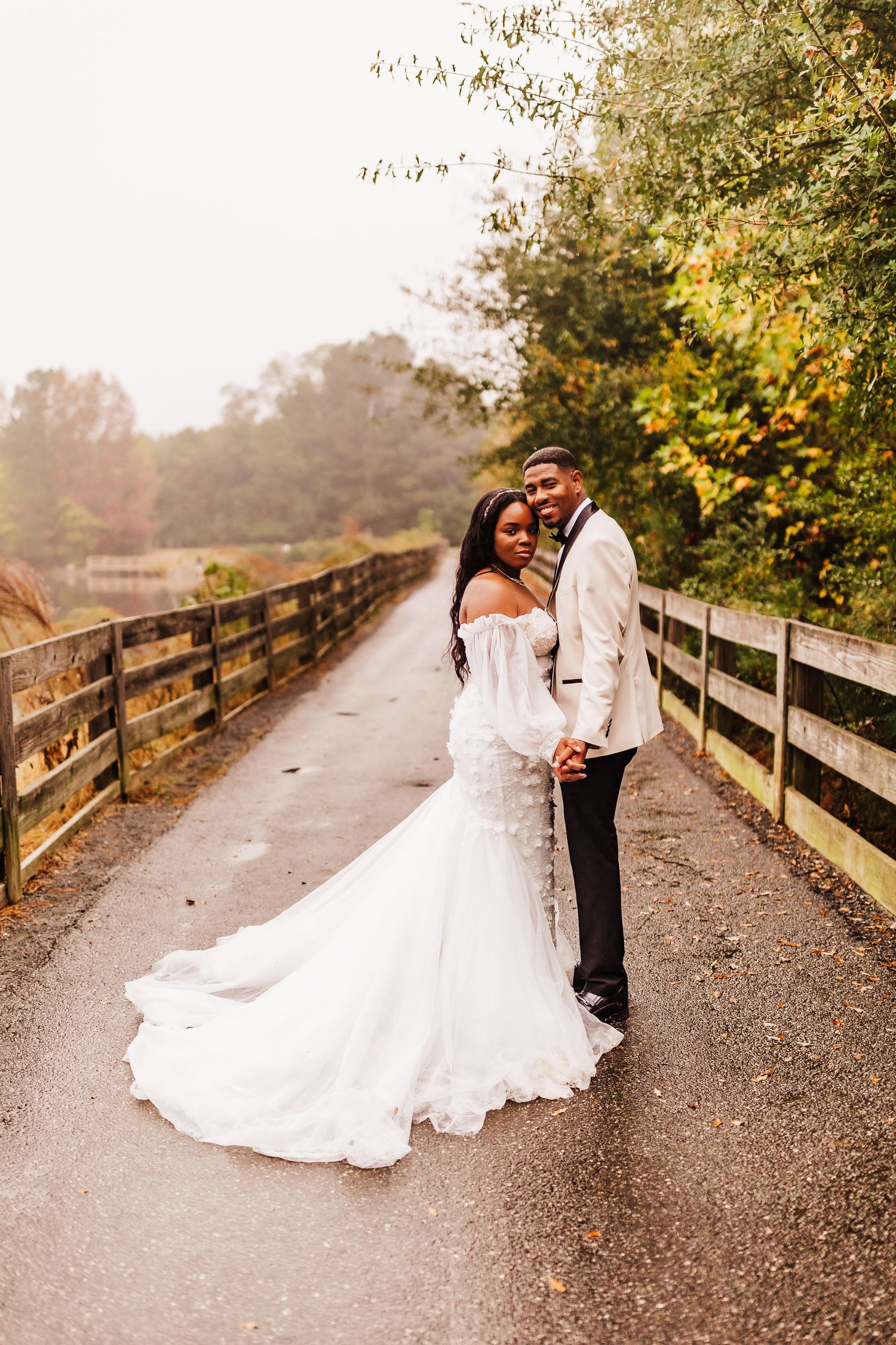 Romantic wedding portraits on a wooden bridge path during a cloudy, foggy day with soft overcast light.