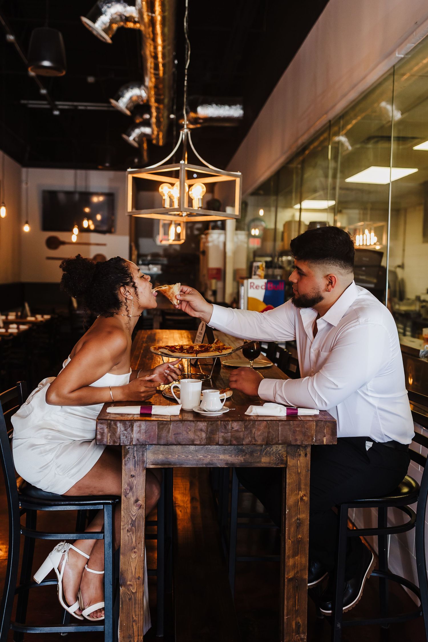 Engaged couple sharing pizza during an engagement session at Vinny’s Little Italy.