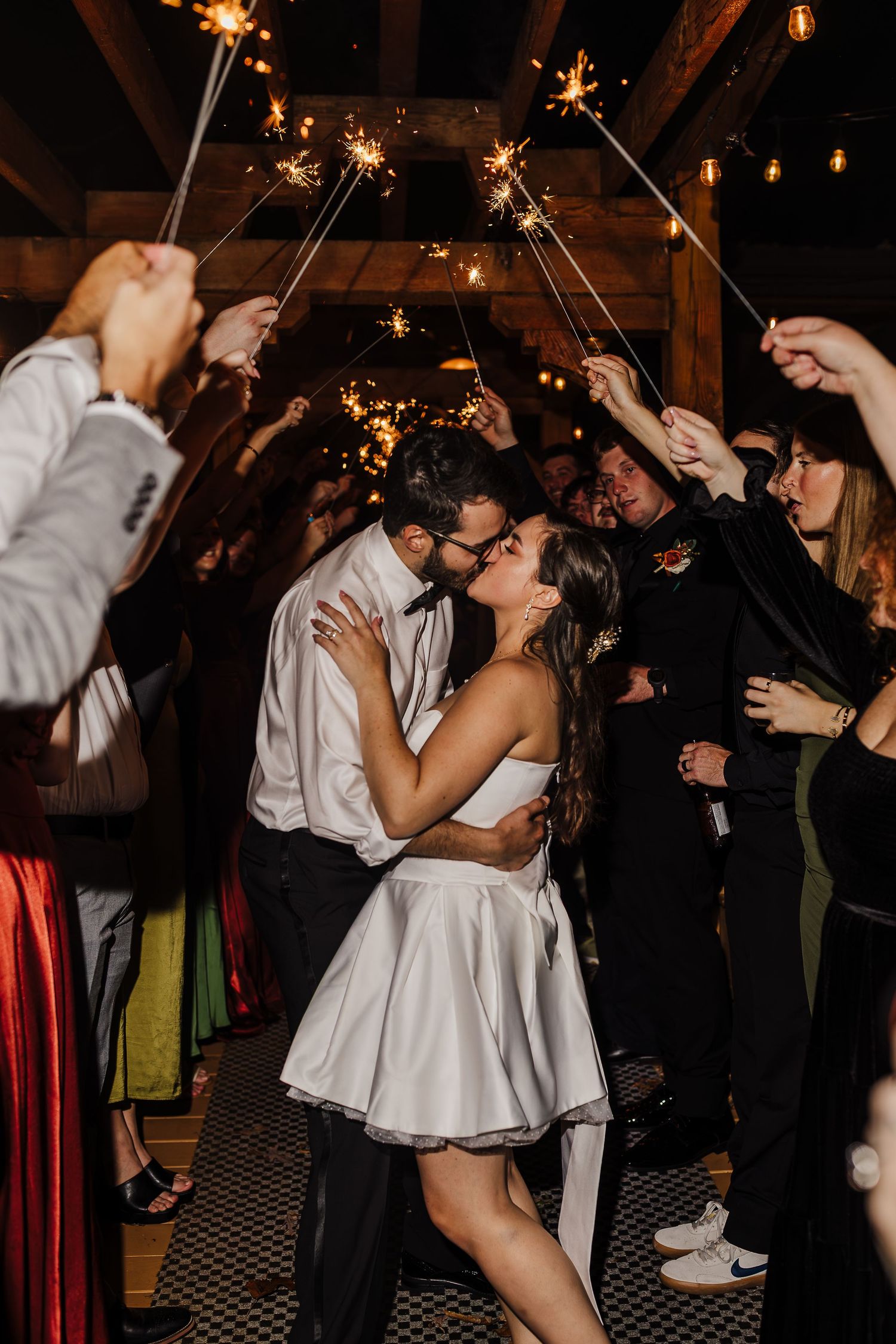 Wedding reception sparkler exit with guests creating a tunnel of light for the celebrating couple.