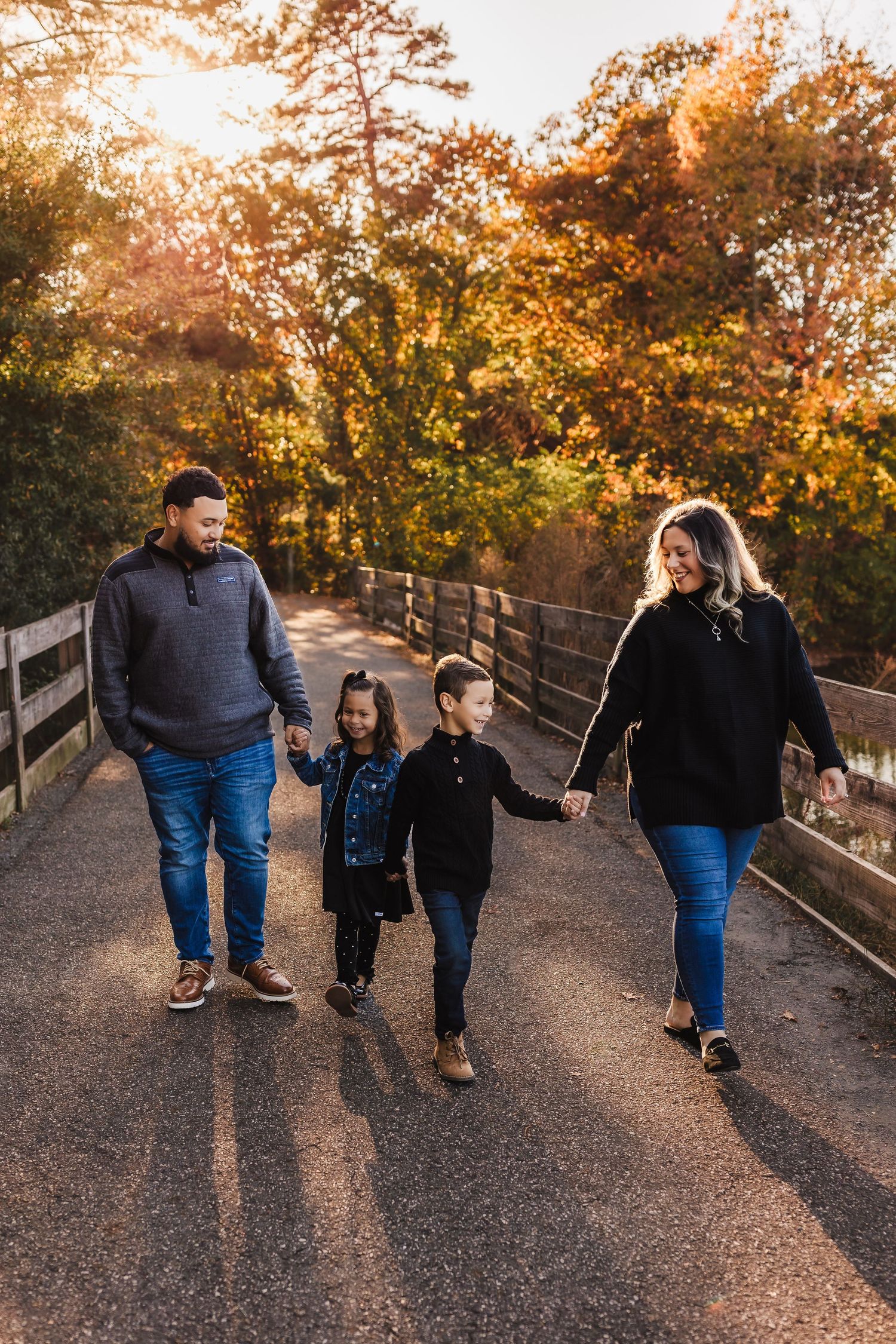 Family walking hand in hand during an outdoor family photo session at Little Mulberry Park in the fall.