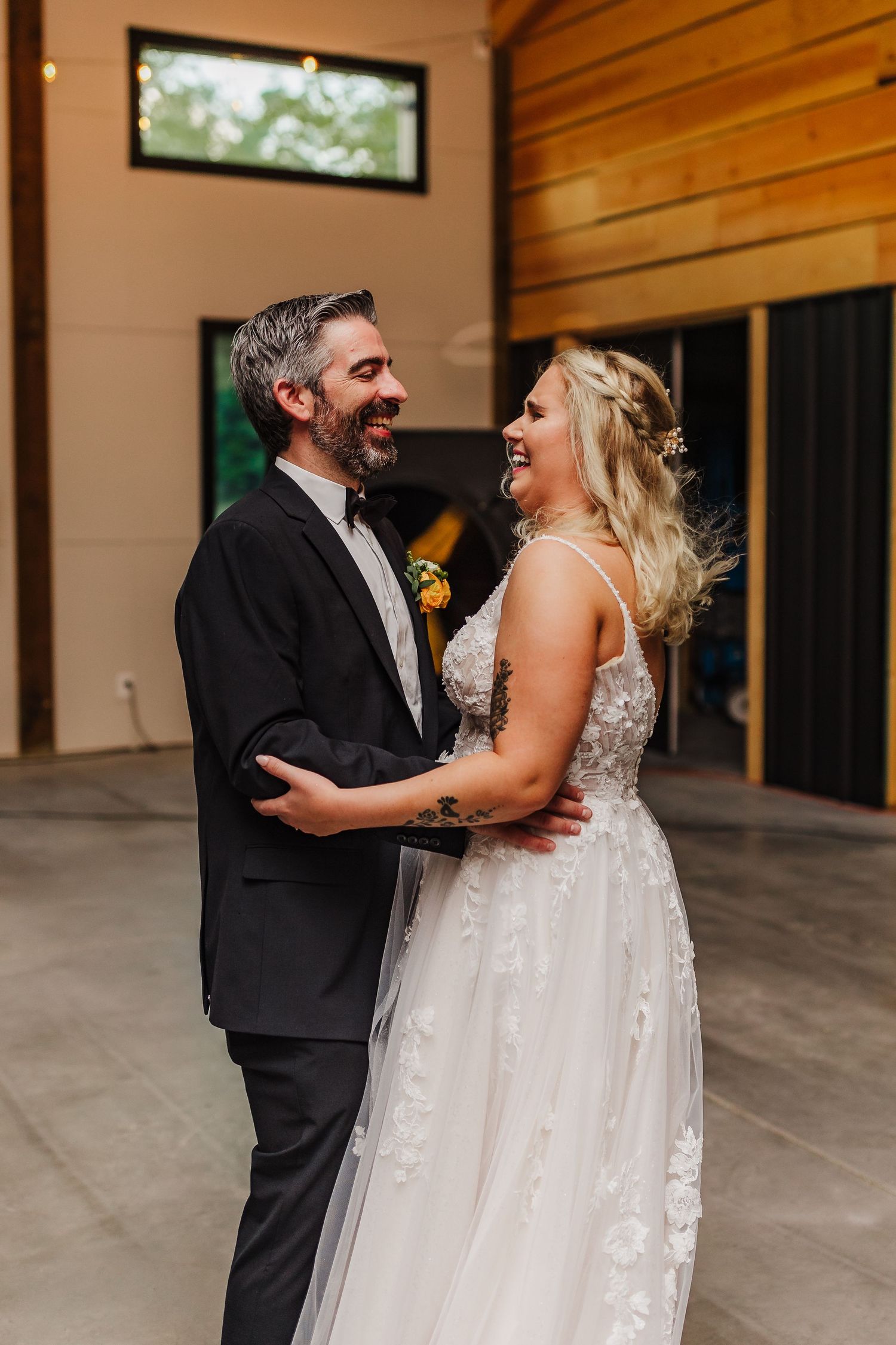 Candid dancing moment in a modern wooden venue with natural lighting.