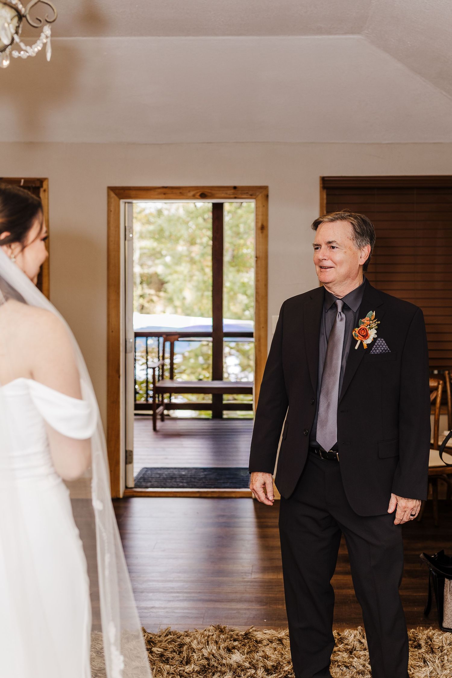 Emotional first look moment between family members before a wedding ceremony in a bright indoor venue.