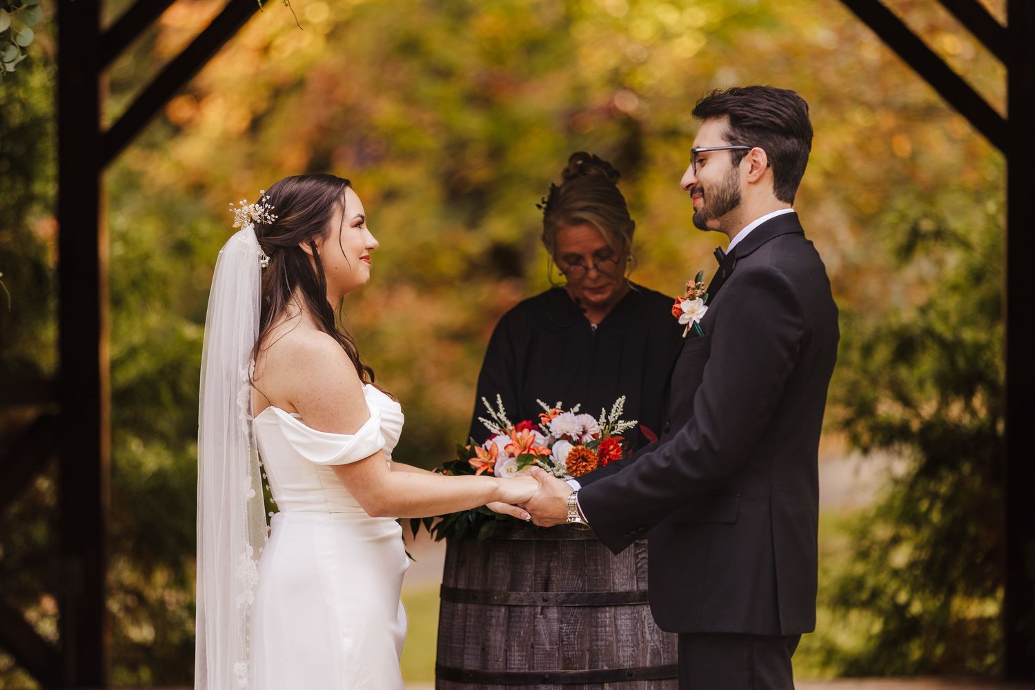 Bride and groom holding hands during an outdoor wedding ceremony at Forrest Hills Resort.
