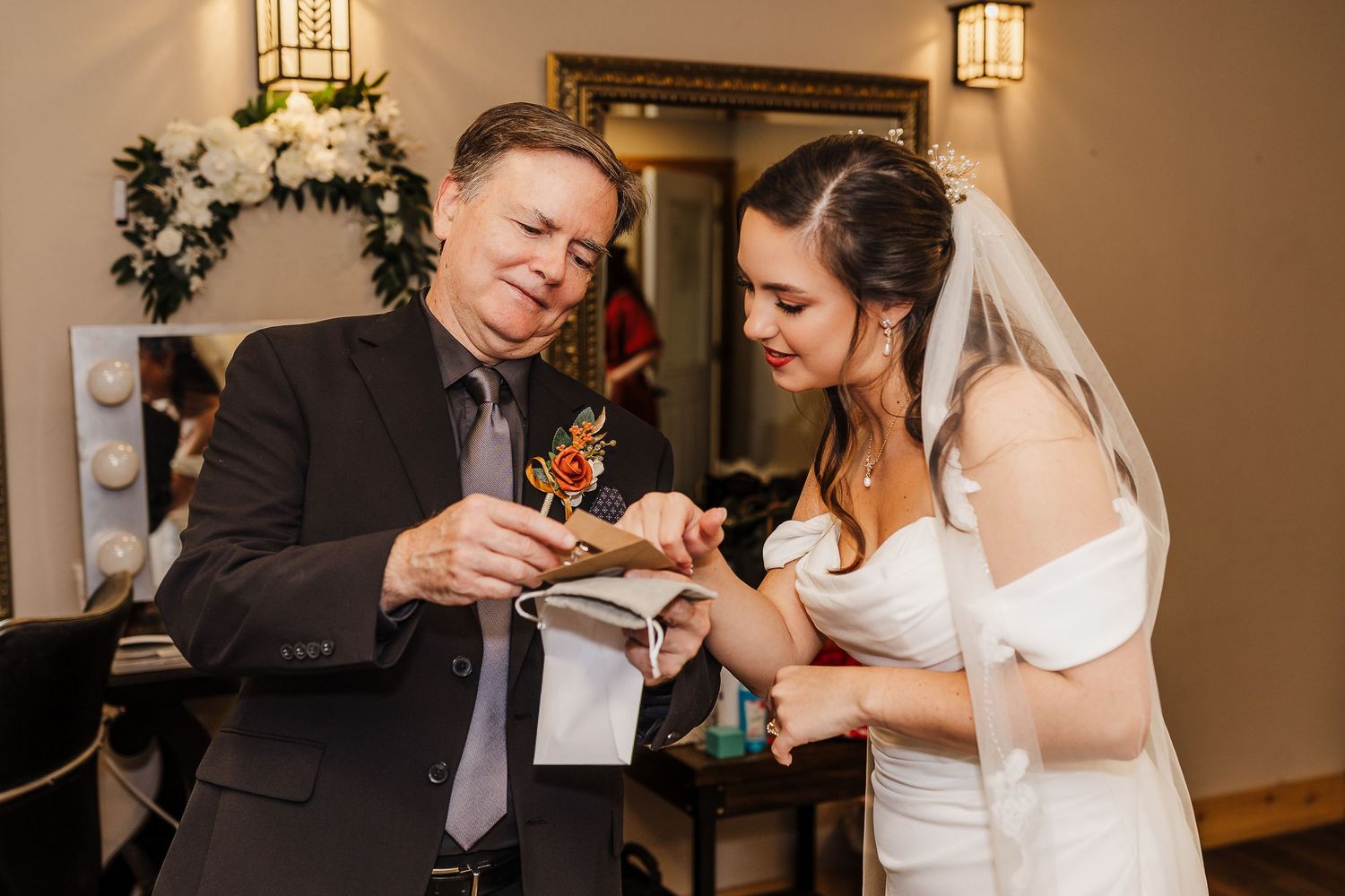 A bride and groom share an intimate moment during their first dance at an indoor wedding reception.