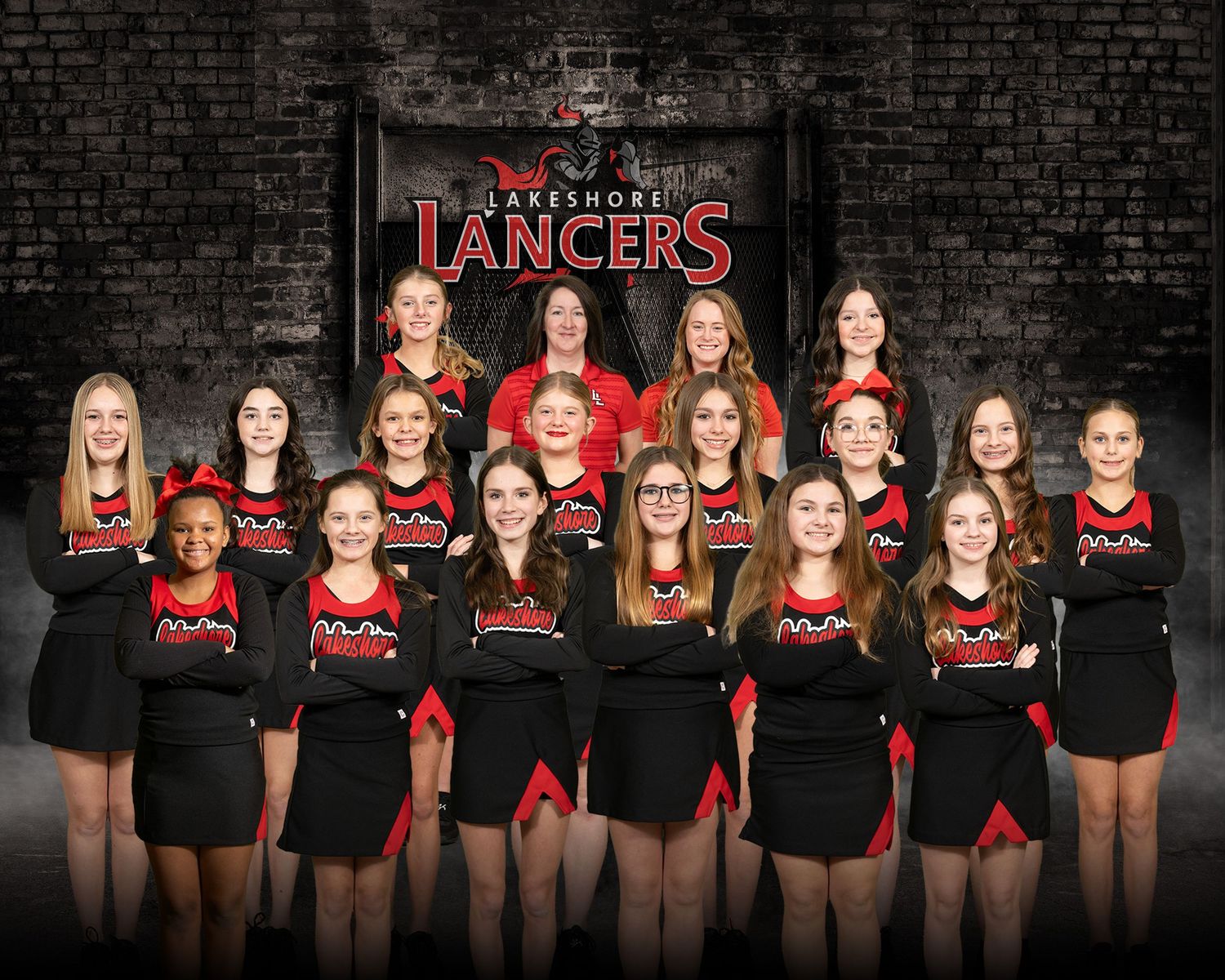 Lakeshore Lancers cheerleading squad posing in black and red uniforms for team photo.