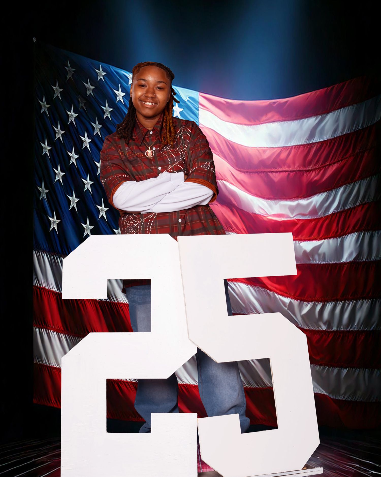 Young person stands confidently with crossed arms beside number 25 in front of American flag backdrop.