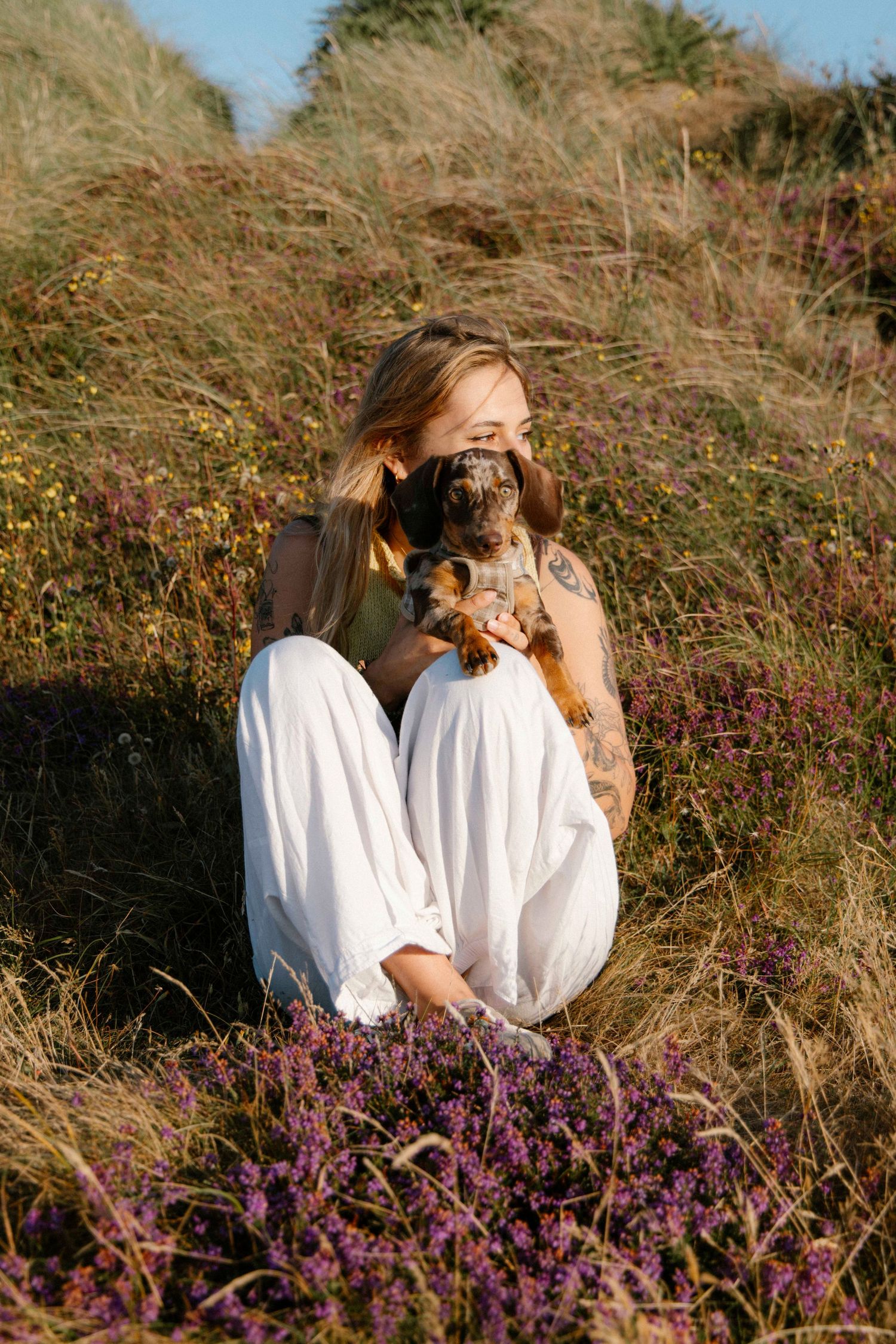 Woman holding her dog in the heathland at Hengistbury head beach