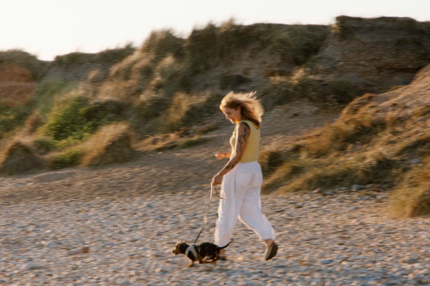 Woman running with her do non the beach