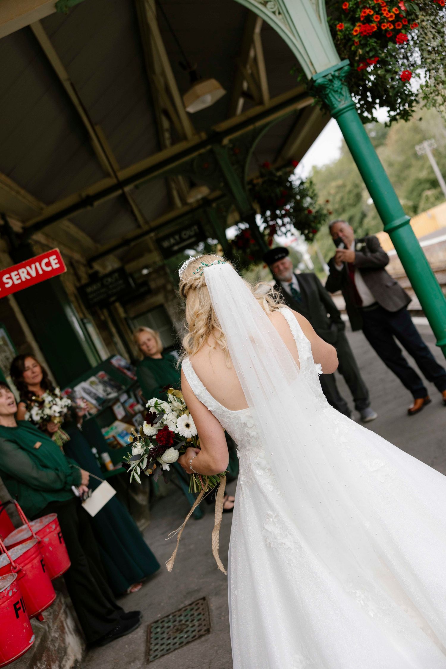 Bride showing of her dress to the bridal party on the platform