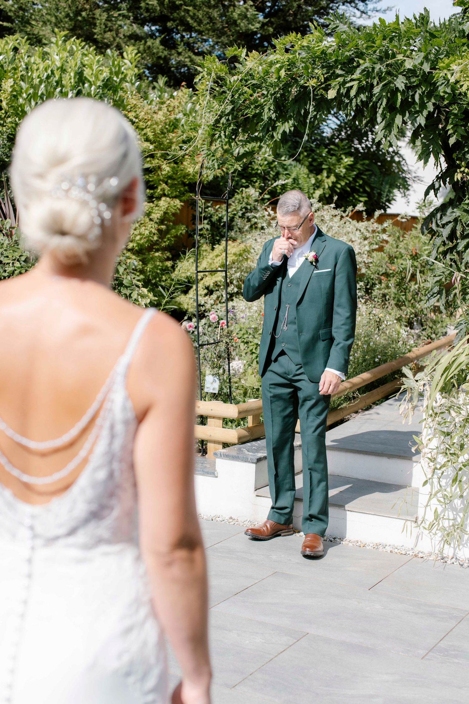 A father reacting to seeing her daughter in her bridal dress for the first time
