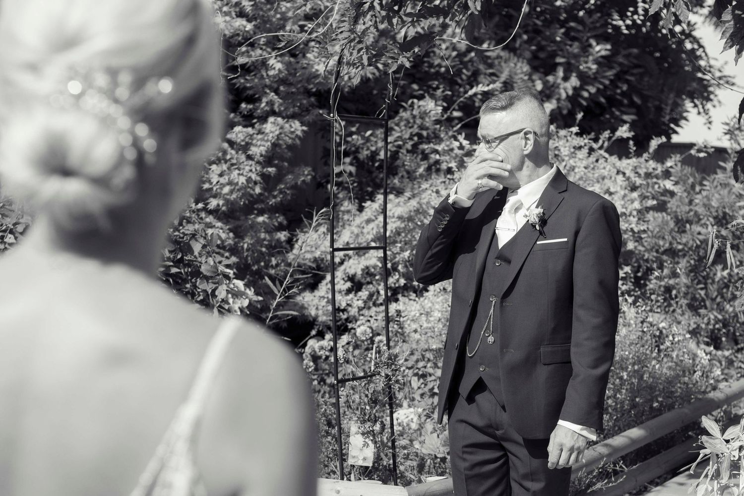 A father crying with happiness when he sees his daughter for the first time in her dress on their wedding day.