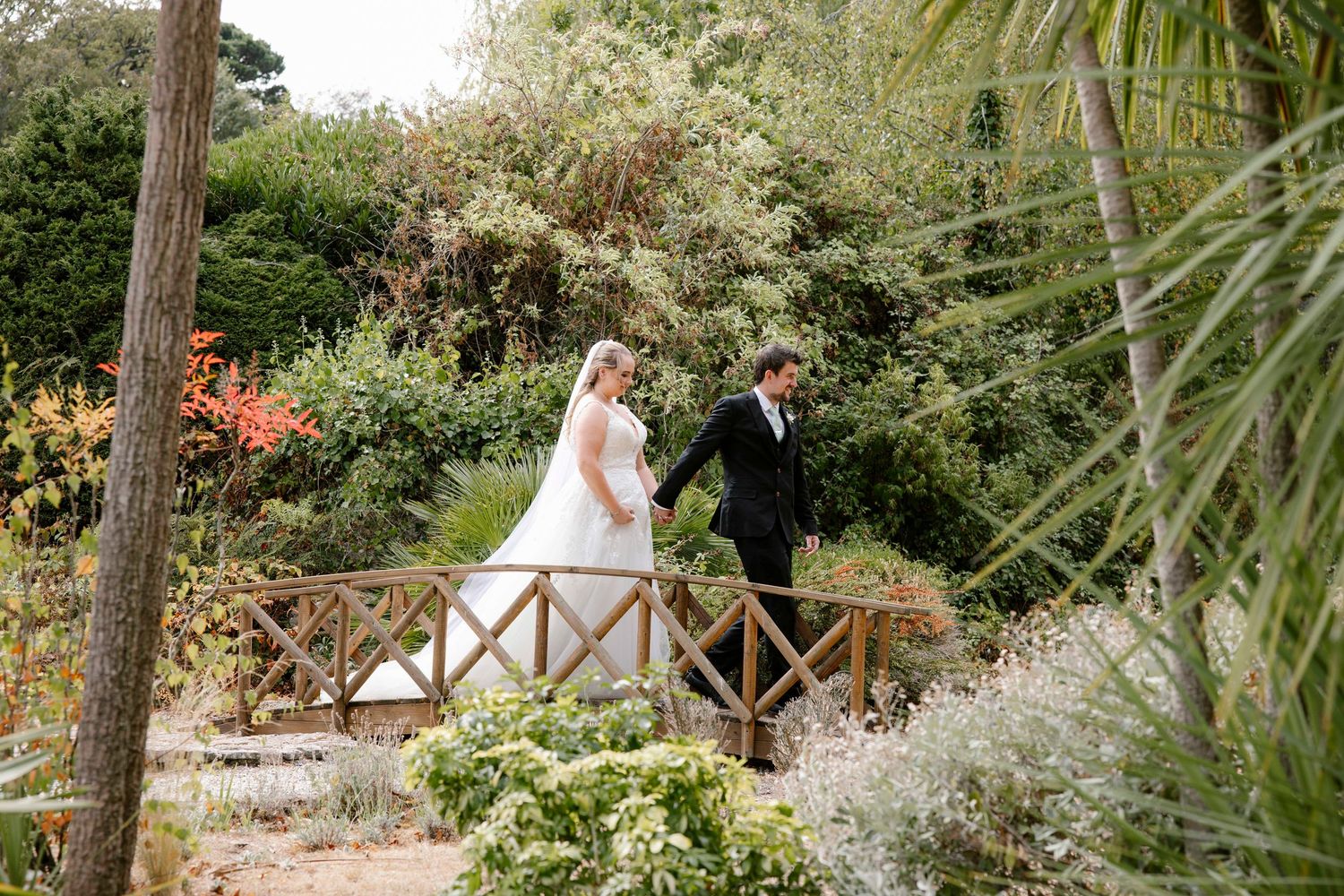 Husband and wife walking across the bridge at Orangery Suite