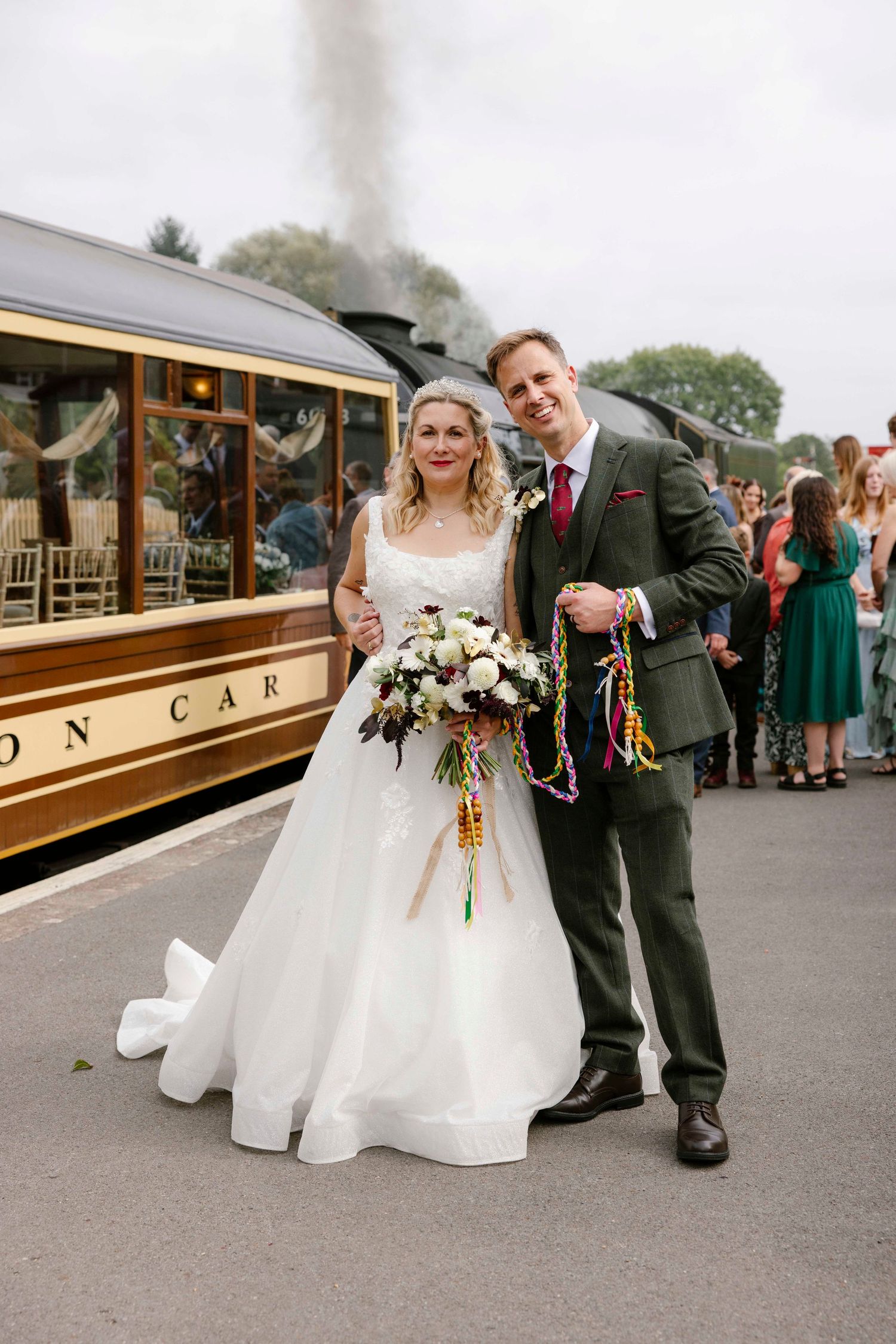 Husband and wife standing in front of Steam train at Swanage railway
