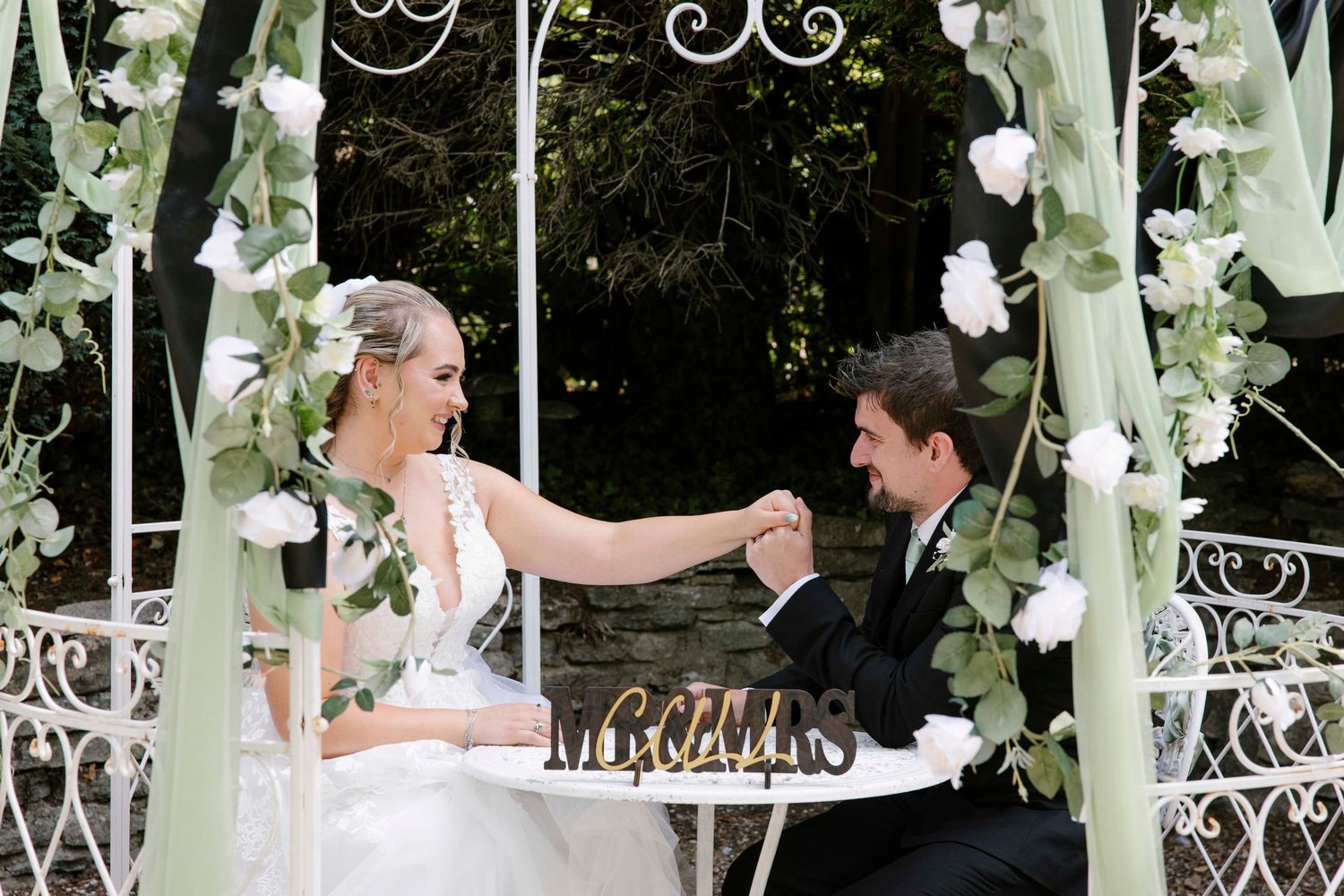 Husband and wife signing the paperwork, husband is looking at his new wife lovingly.