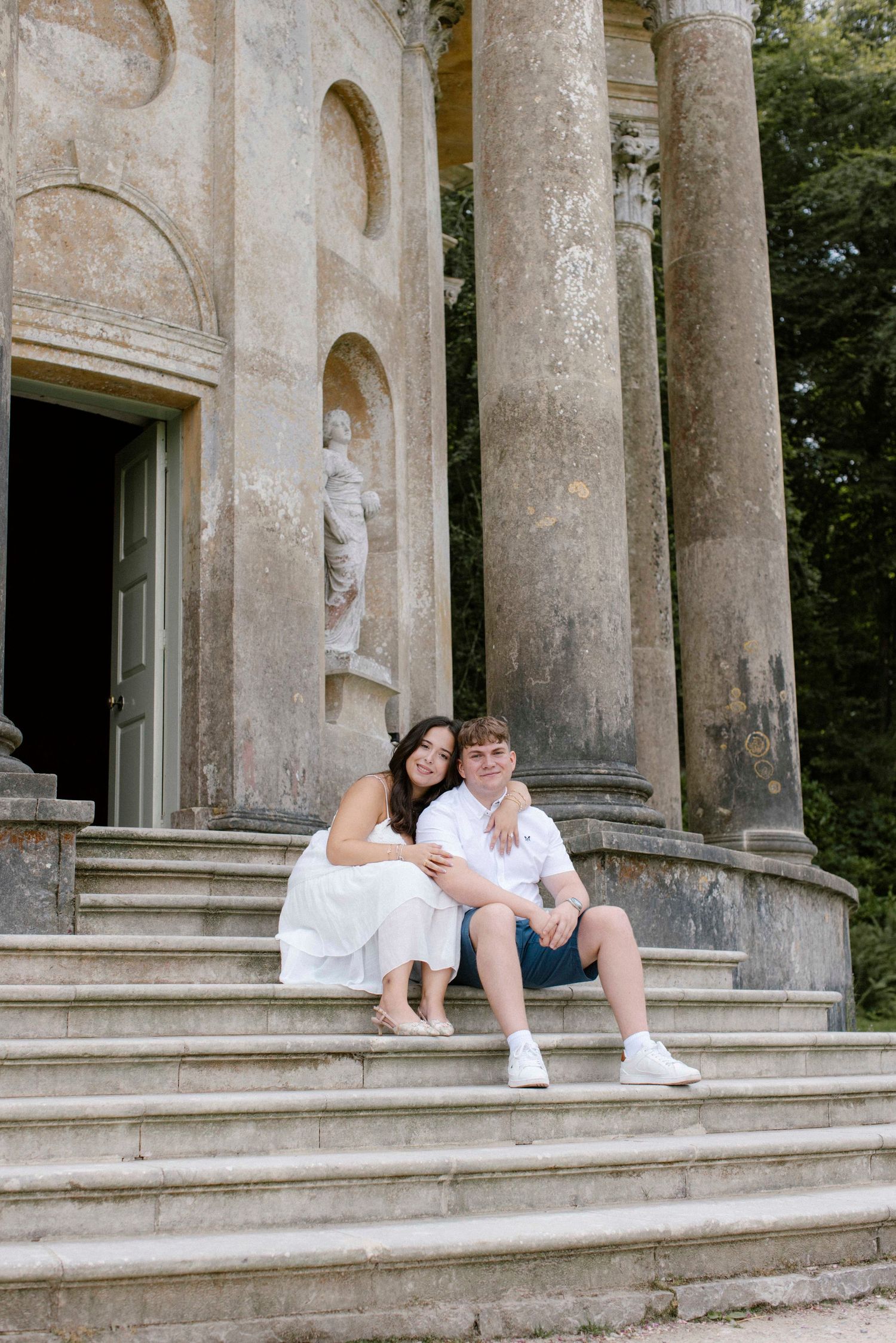 New engaged couple sitting at Temple of Apollo, StourHead