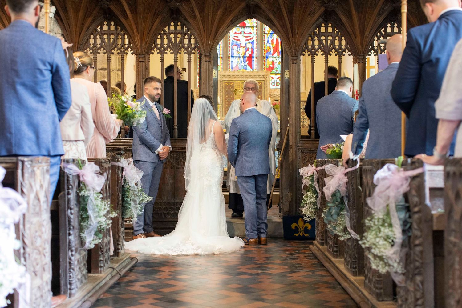 Bride and groom from the back of the church, surrounded by friends and family