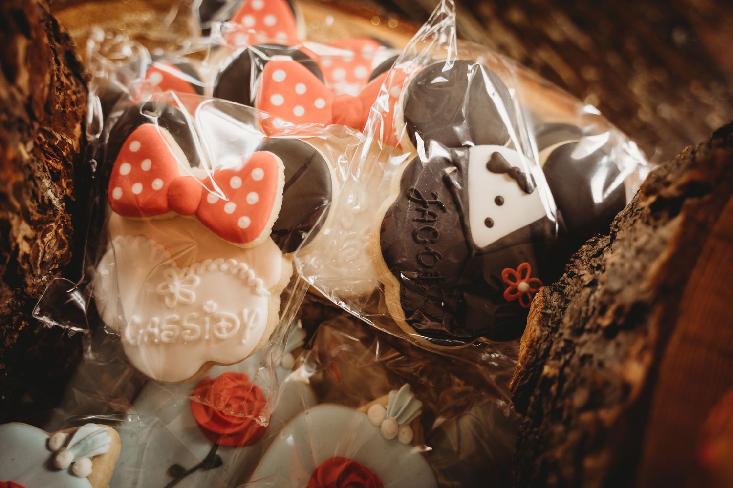 Mickey and Minnie Mouse shaped decorated sugar cookies in individual clear bags as Disney wedding favors.