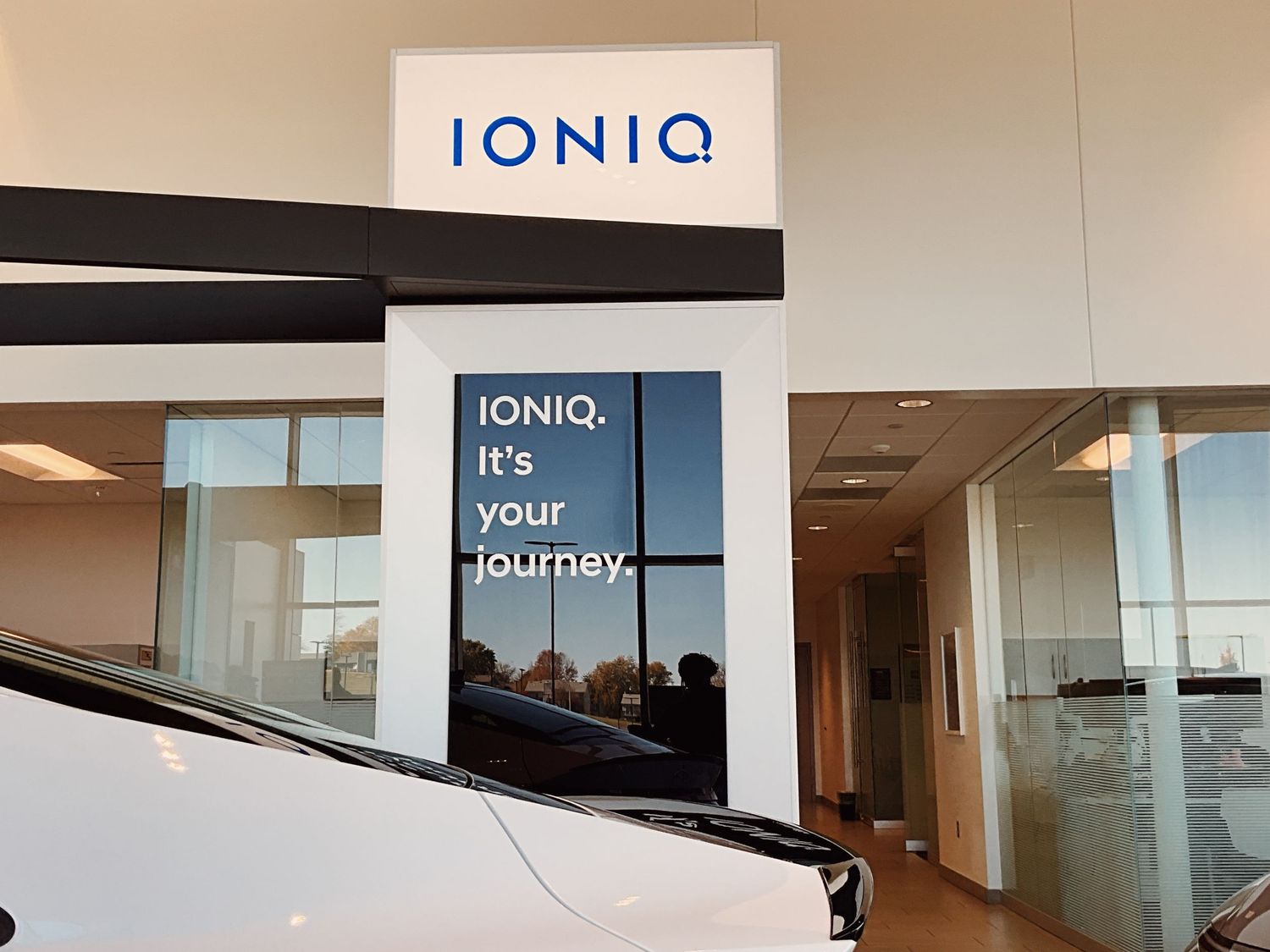 Hyundai IONIQ dealership display with branded signage reading 'IONIQ. It's your journey.' inside a modern showroom.