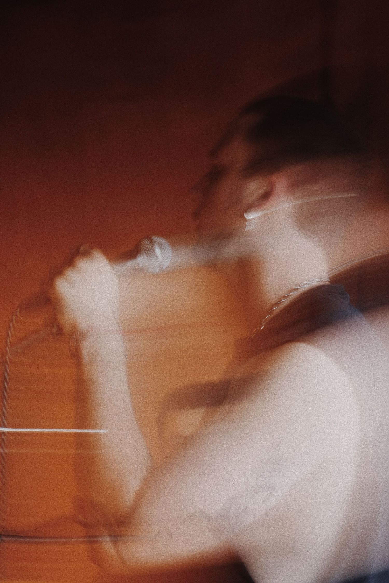 Blurred motion photo of a singer performing with a microphone, creating an artistic double exposure effect.