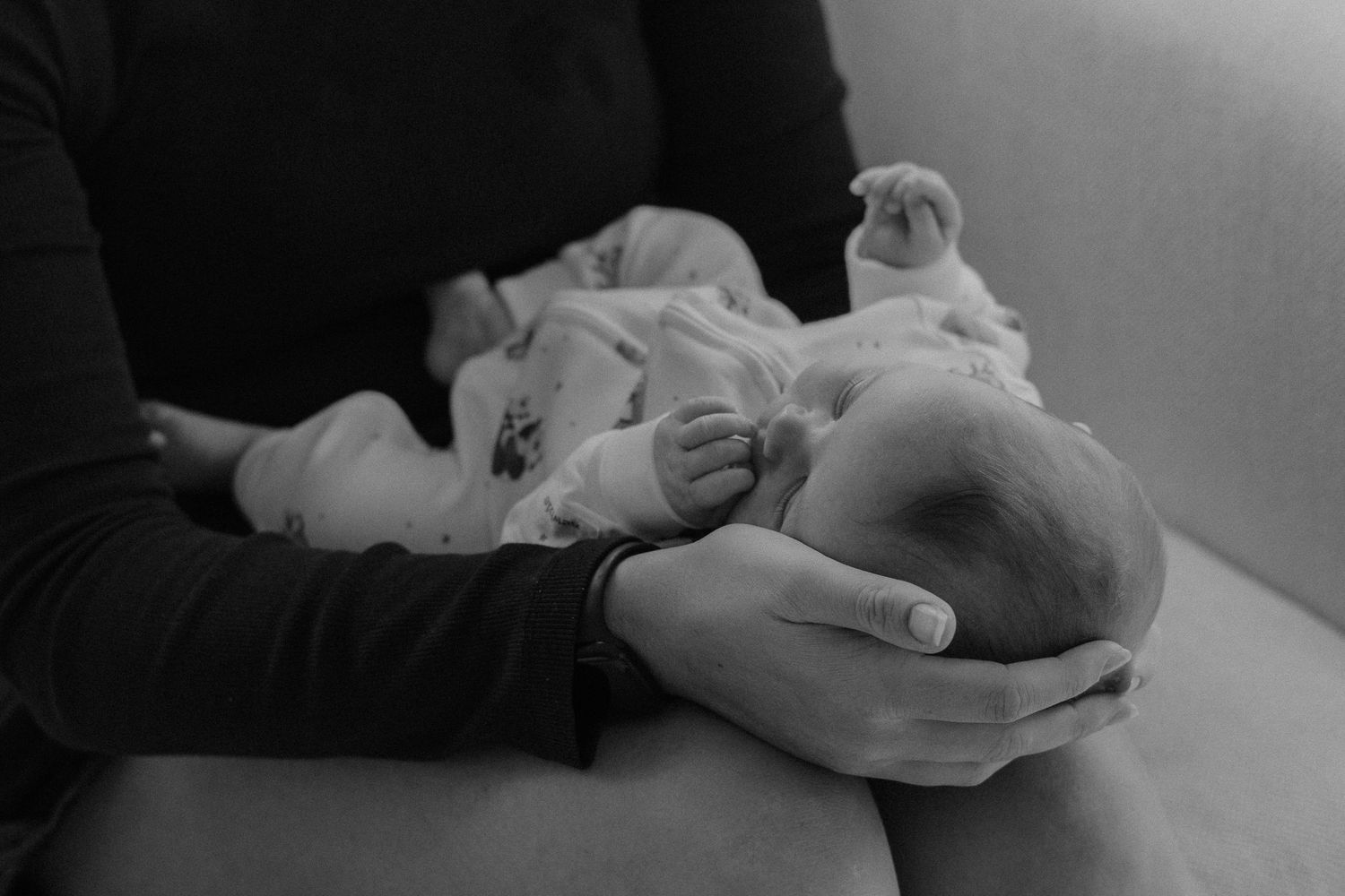 Nyfödd bebis tillsammans med sin mamma under familjefotografering