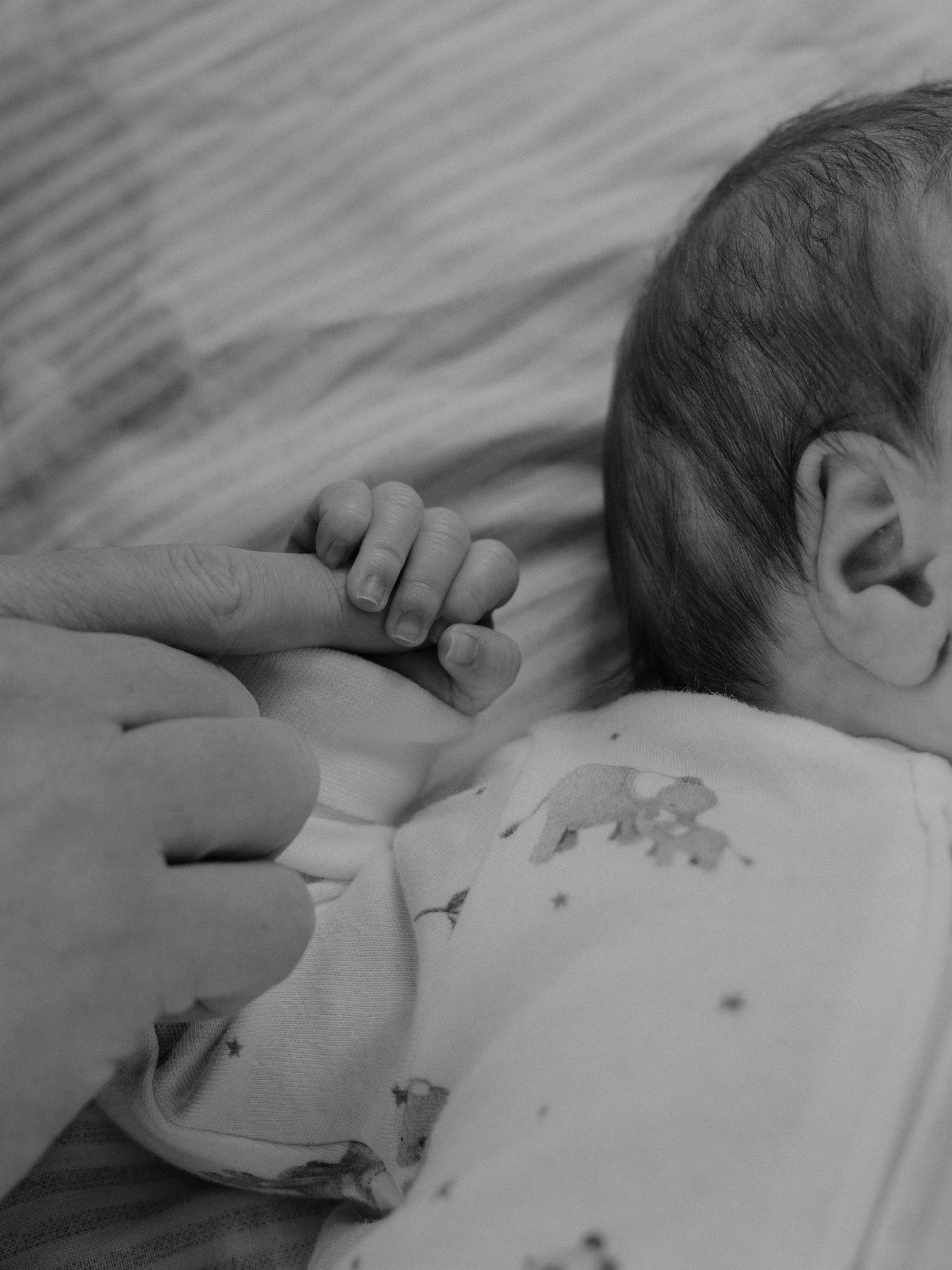 Intim närbild på nyfödd bebis under familjefotografering.