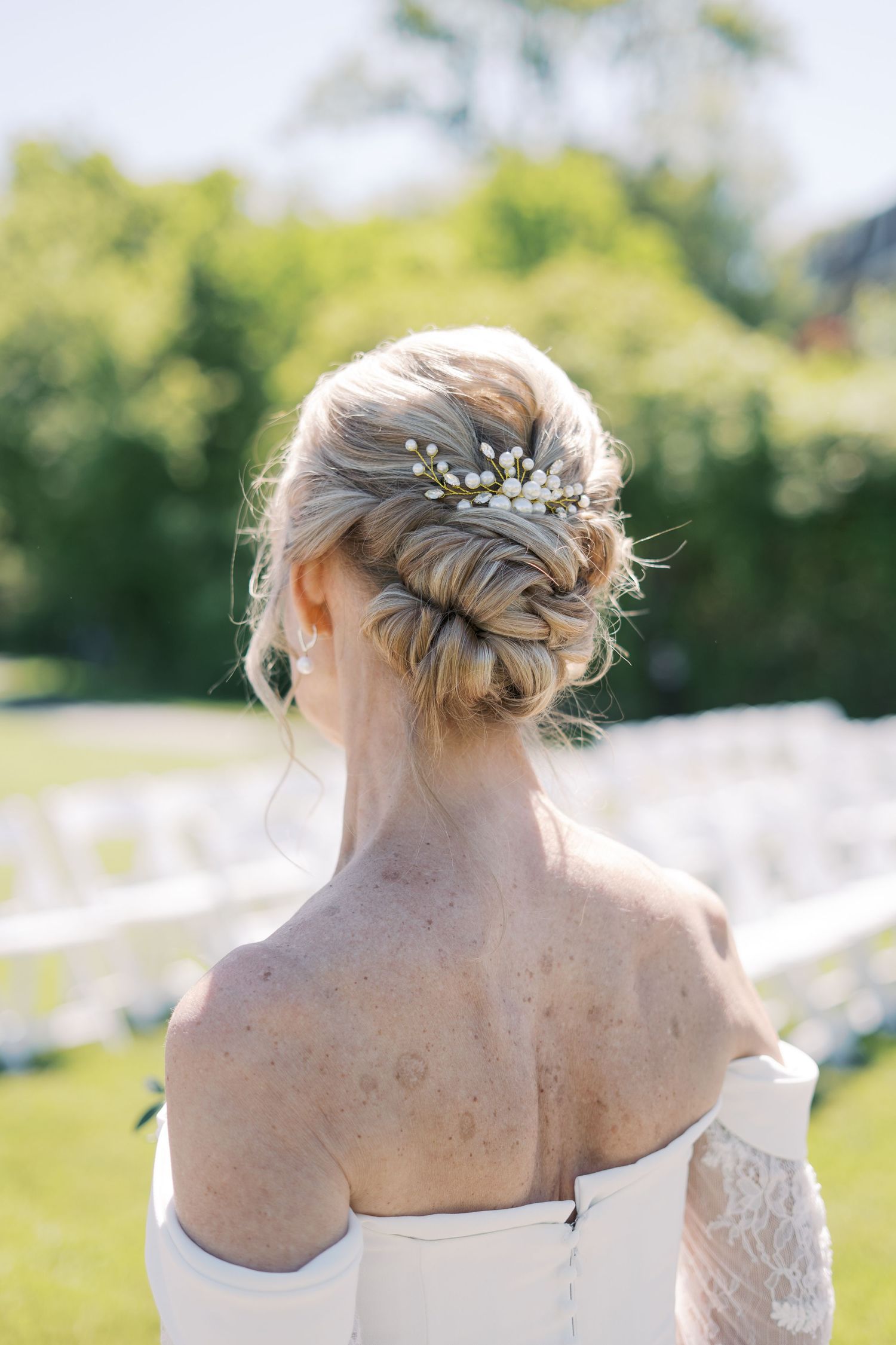 Detailed view of a bride’s classic updo wedding hairstyle featuring a delicate pearl hairpiece for a coastal Rhode Island wedding.