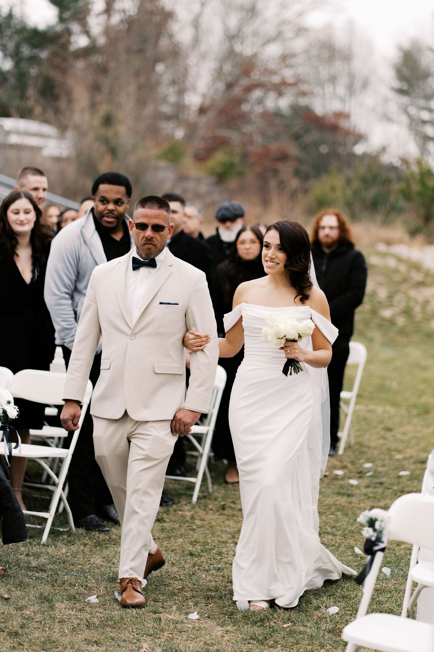 A bride being escorted down the aisle toward a winter ceremony overlooking the Wareham cranberry bogs.